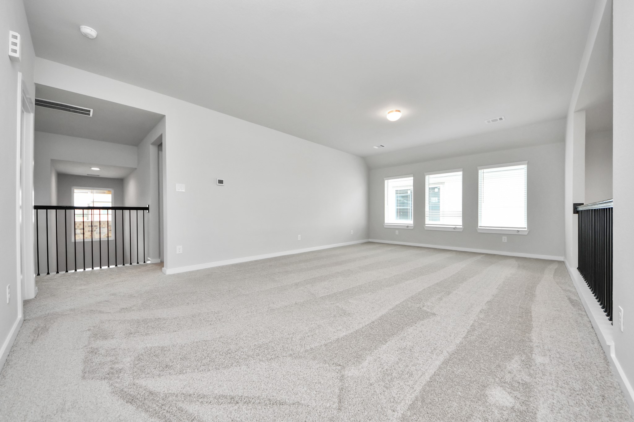 Ascend to relaxation in this fantastic game room! Ideal for both casual gatherings and adult gaming, it boasts plush carpet, lofty ceilings, custom paint, and ample windows for abundant natural light. Sample photo of completed home with similar floor plan. Actual colors and selections may vary.