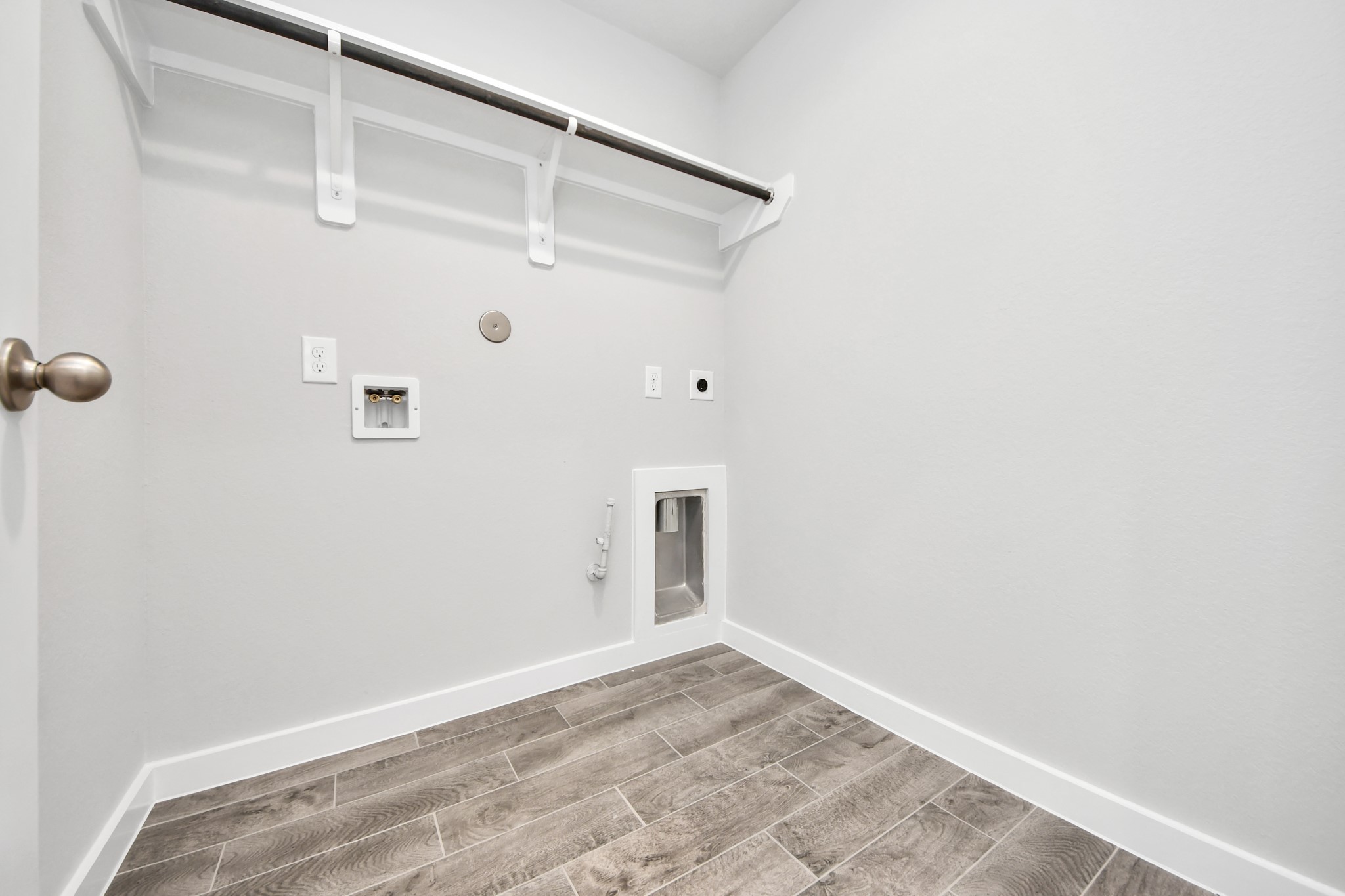 A perfect blend of functionality and comfort. Capture the essence of easy living with a first-floor laundry room, thoughtfully equipped with shelving for effortless organization. Both electric and gas connections available. Sample photo of completed home with similar floor plan. Actual colors and selections may vary.