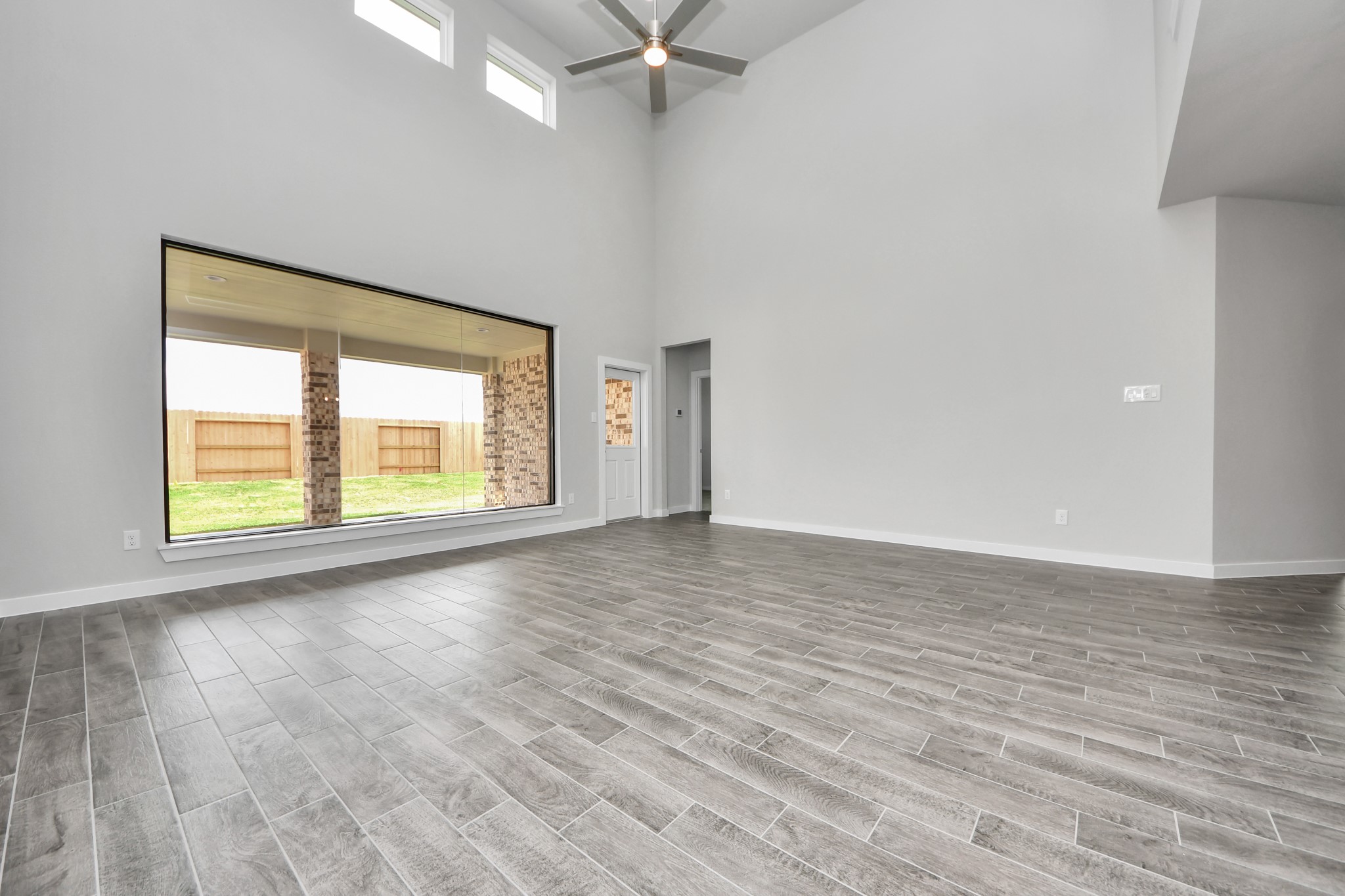 Welcome family and guests to your charming living room! With its high ceilings, recessed lighting, ceiling fan, custom paint, beautiful flooring, and large windows that let in abundant natural light, this room is perfect for gatherings. Sample photo of completed home with similar floor plan. Actual colors and selections may vary.