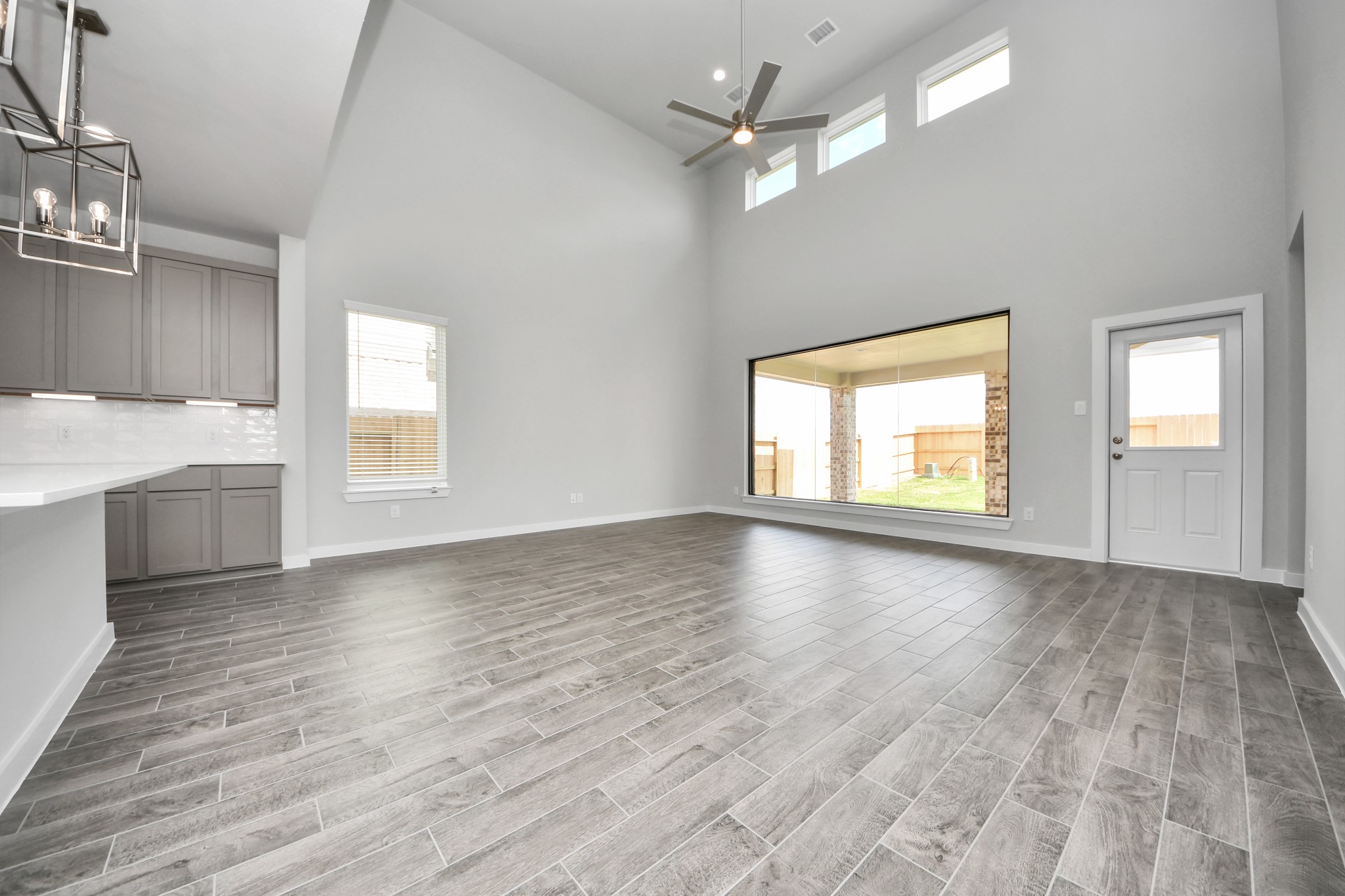 Gather the family and guests together in your lovely living room! Featuring soaring high ceilings, recessed lighting, ceiling fan, custom paint, gorgeous floors, and large windows that provide plenty of natural lighting throughout the day. Sample photo of completed home with similar floor plan. Actual colors and selections may vary.