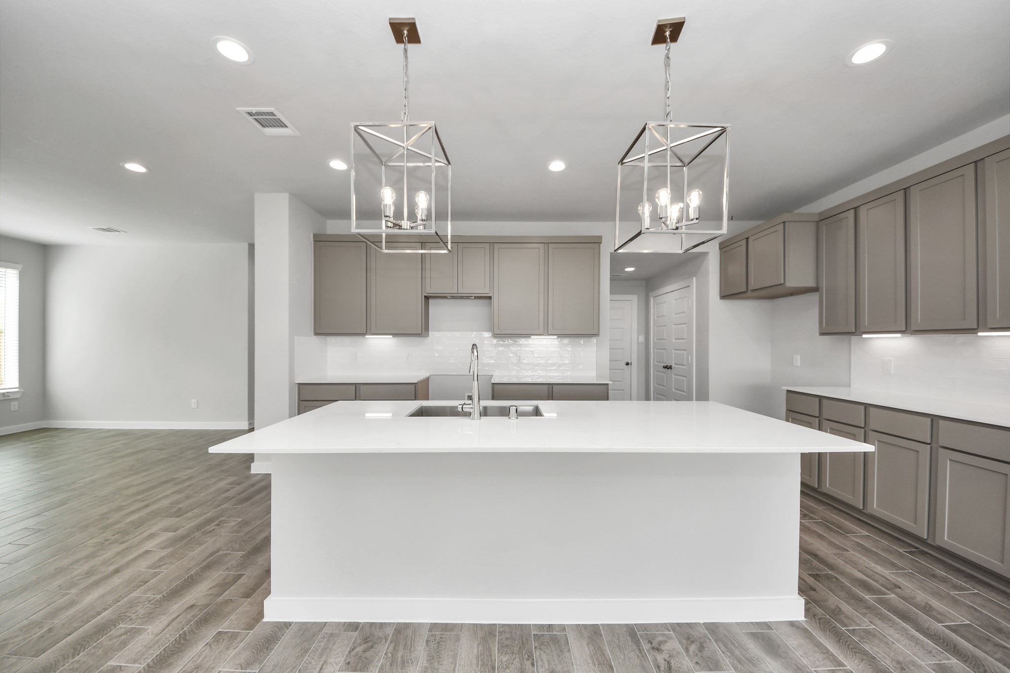 This kitchen is by far any chefs dream! This spacious kitchen features high ceilings, stained wood cabinets, granite countertop, SS appliances, modern tile backsplash, recessed lighting, extended counter space, granite kitchen island with double sink, and space for breakfast bar, and a walk-in pantry all overlooking your huge family room. Sample photo of completed home with similar floor plan. Actual colors and selections may vary.