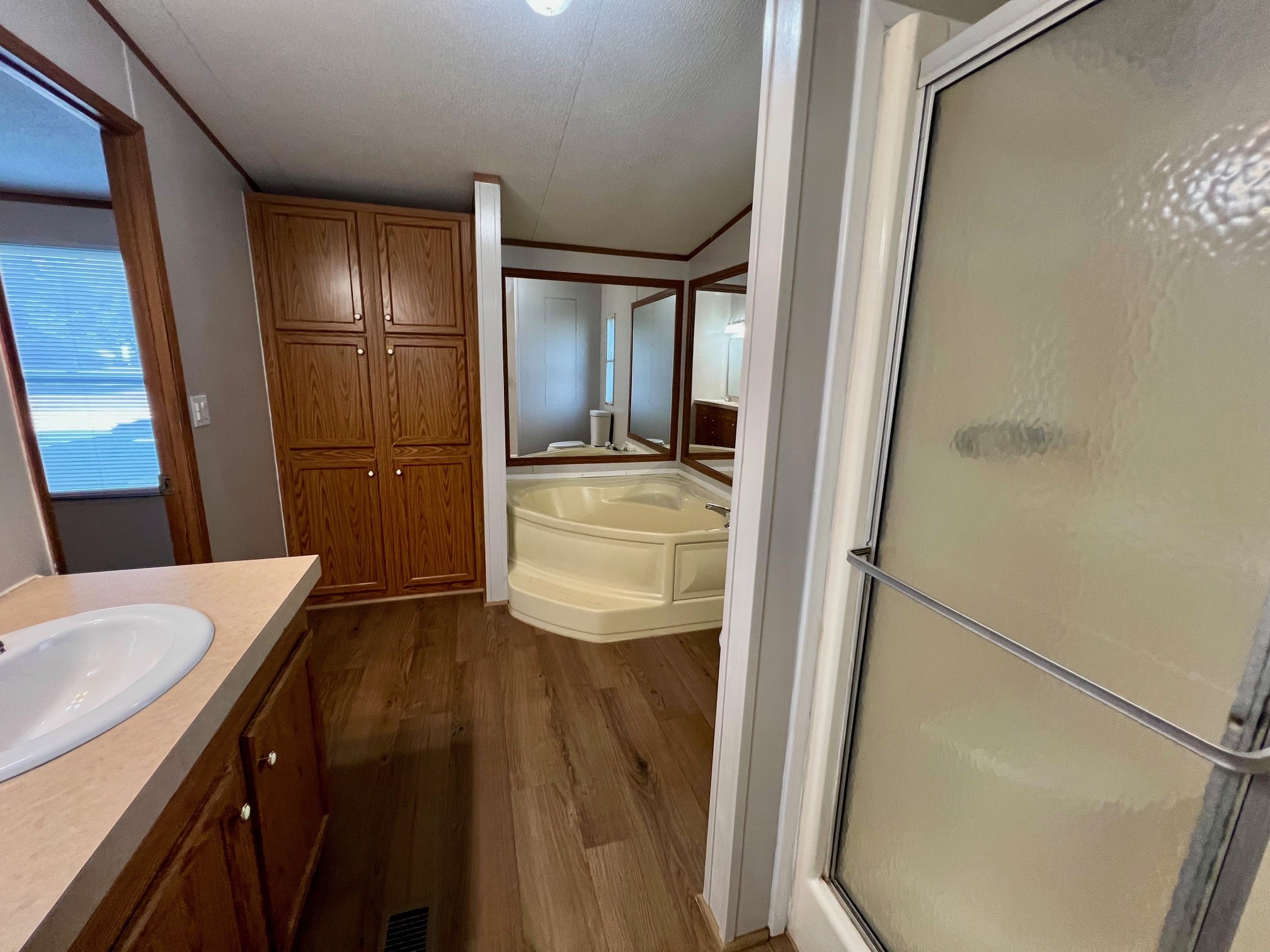 Primary bath with soaking tub and linen closet.