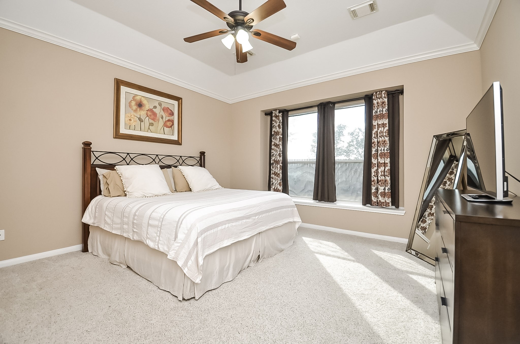 The primary suite boasts a charming window seat and elegant tray ceiling.