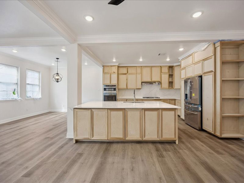 Kitchen  Spacious kitchen taking shape with custom on-site-crafted cabinetry, generous counter space, stainless-steel appliances, gas cooking, and an oversized island. Cabinetry and finish work are still underway.