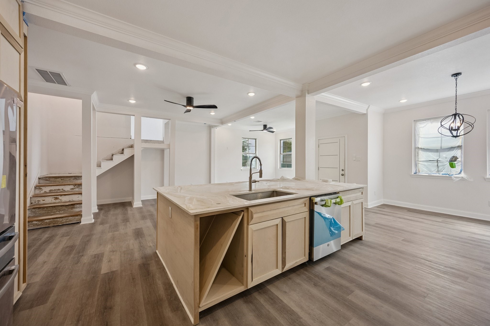 Oversized kitchen island overlooking the spacious living area and staircase, highlighting the homes open-concept design and seamless flow.