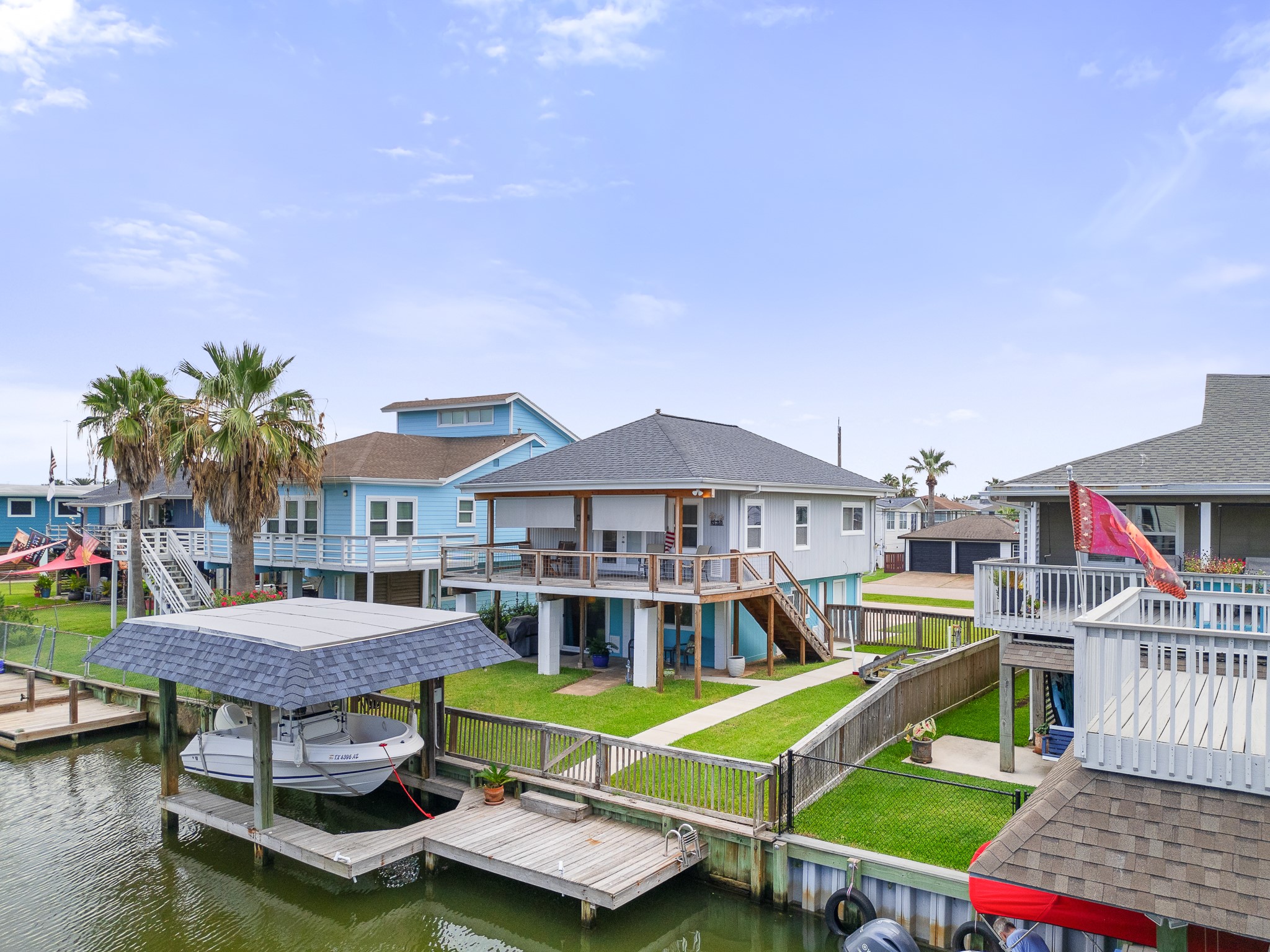 Rear exterior with spacious covered deck overlooking the yard and canal. Rear exterior with spacious covered deck overlooking the yard and canal.
