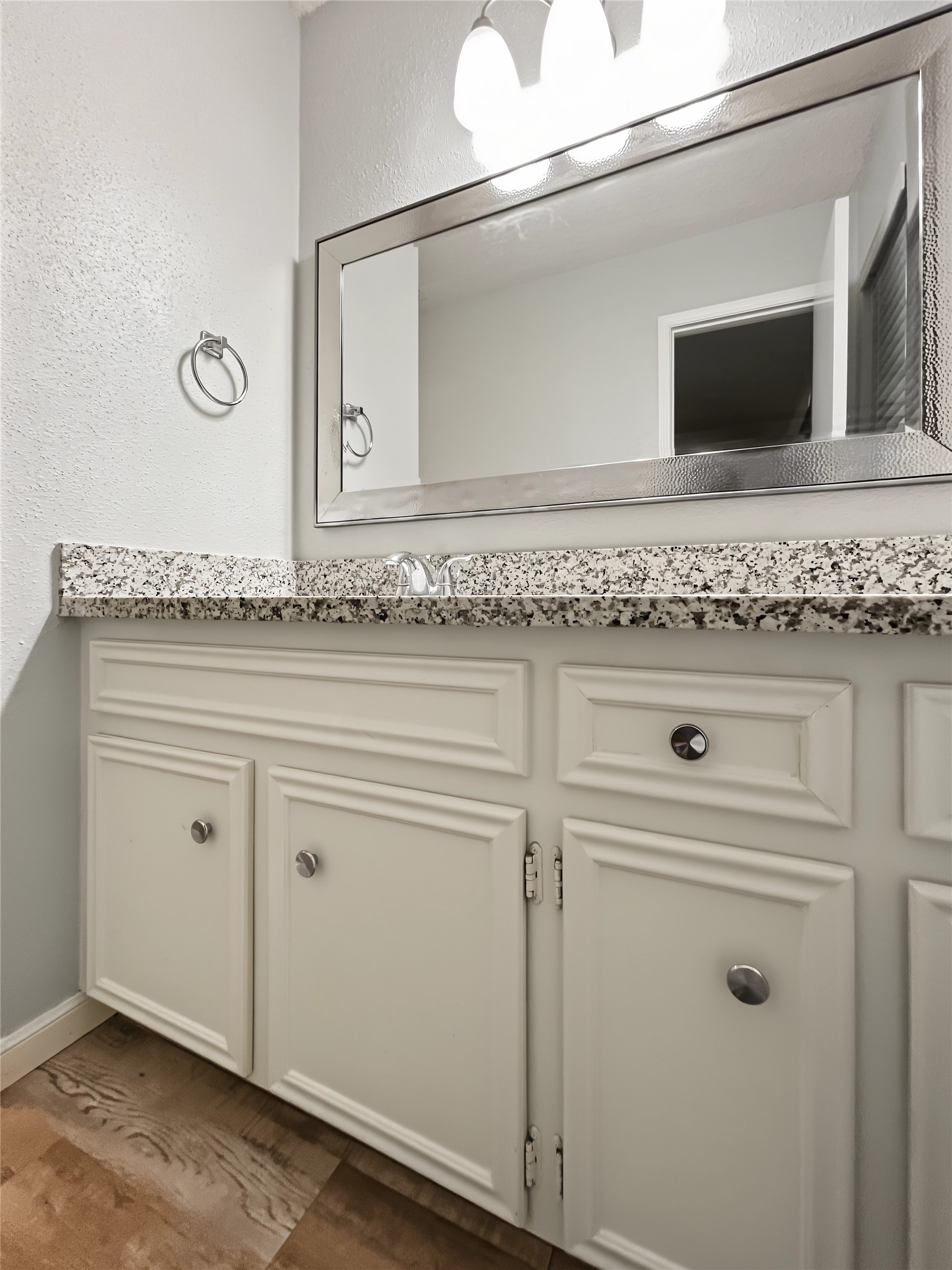 View of the vanity in the secondary bathroom loaded with granite countertops.