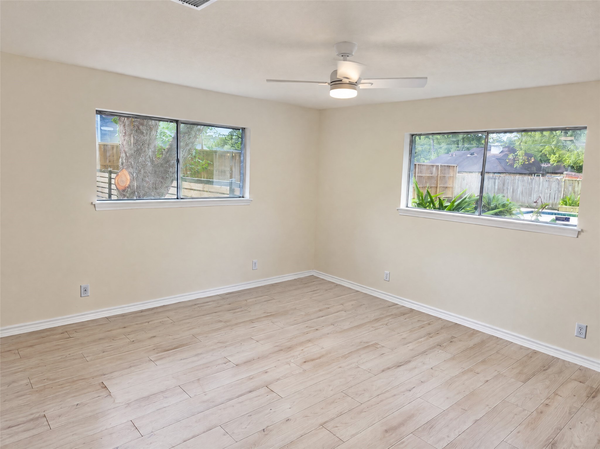 Tucked away for peace and quiet, the primary bedroom boasts ample proportions, clean lines, and an overhead ceiling fan.