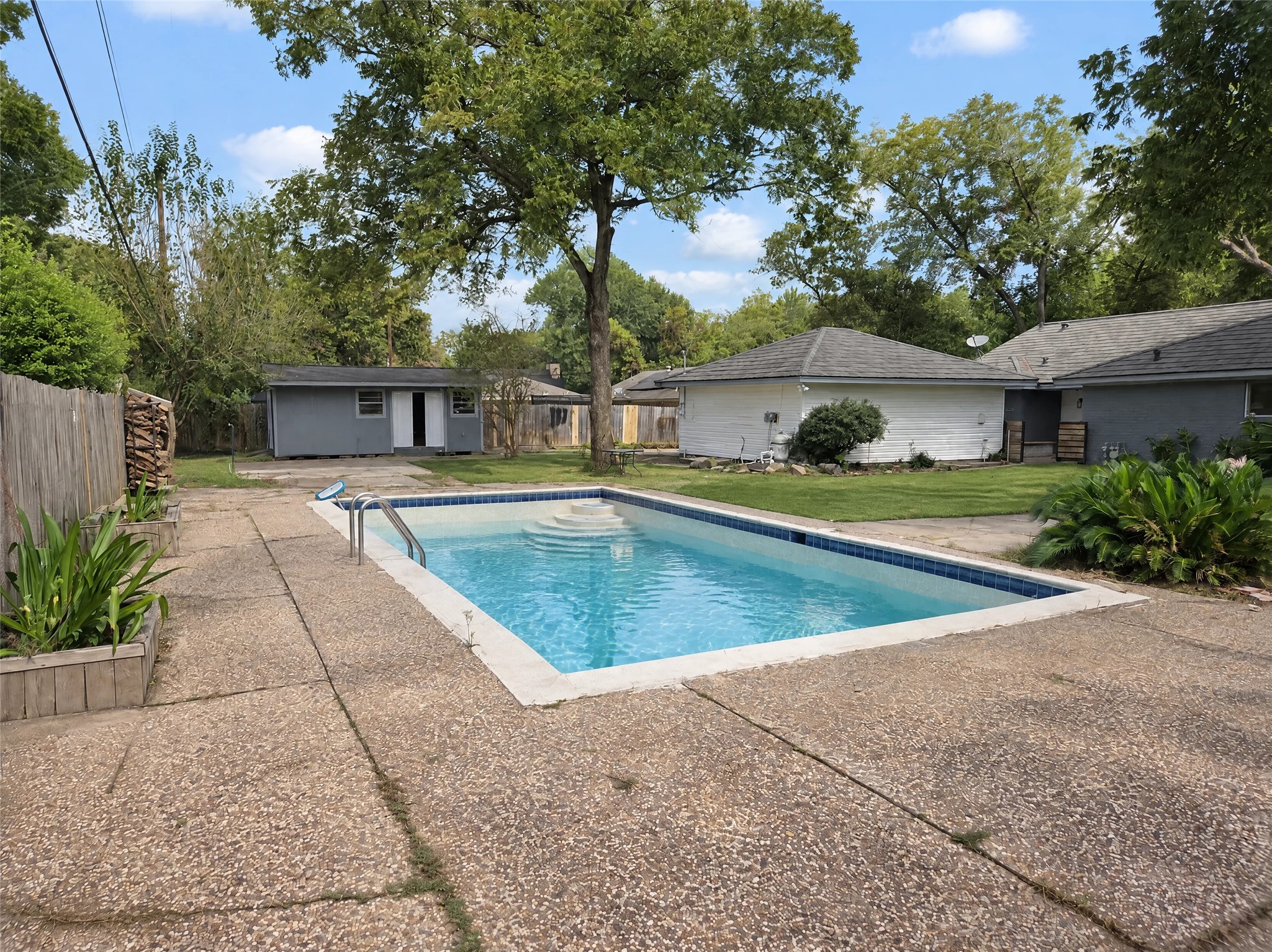 Surrounded by an expansive patio deck, lush lawn, mature trees, and privacy fencing, this space is built for weekend barbecues and summer relaxation.