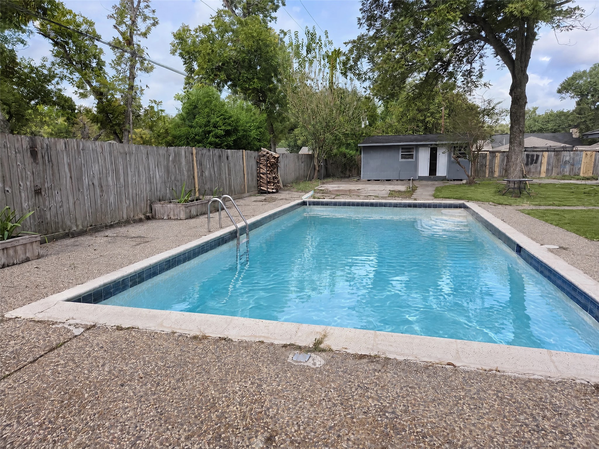 Step outside into your personal paradise featuring an in-ground swimming pool with walk-in entry steps and classic waterline tile.