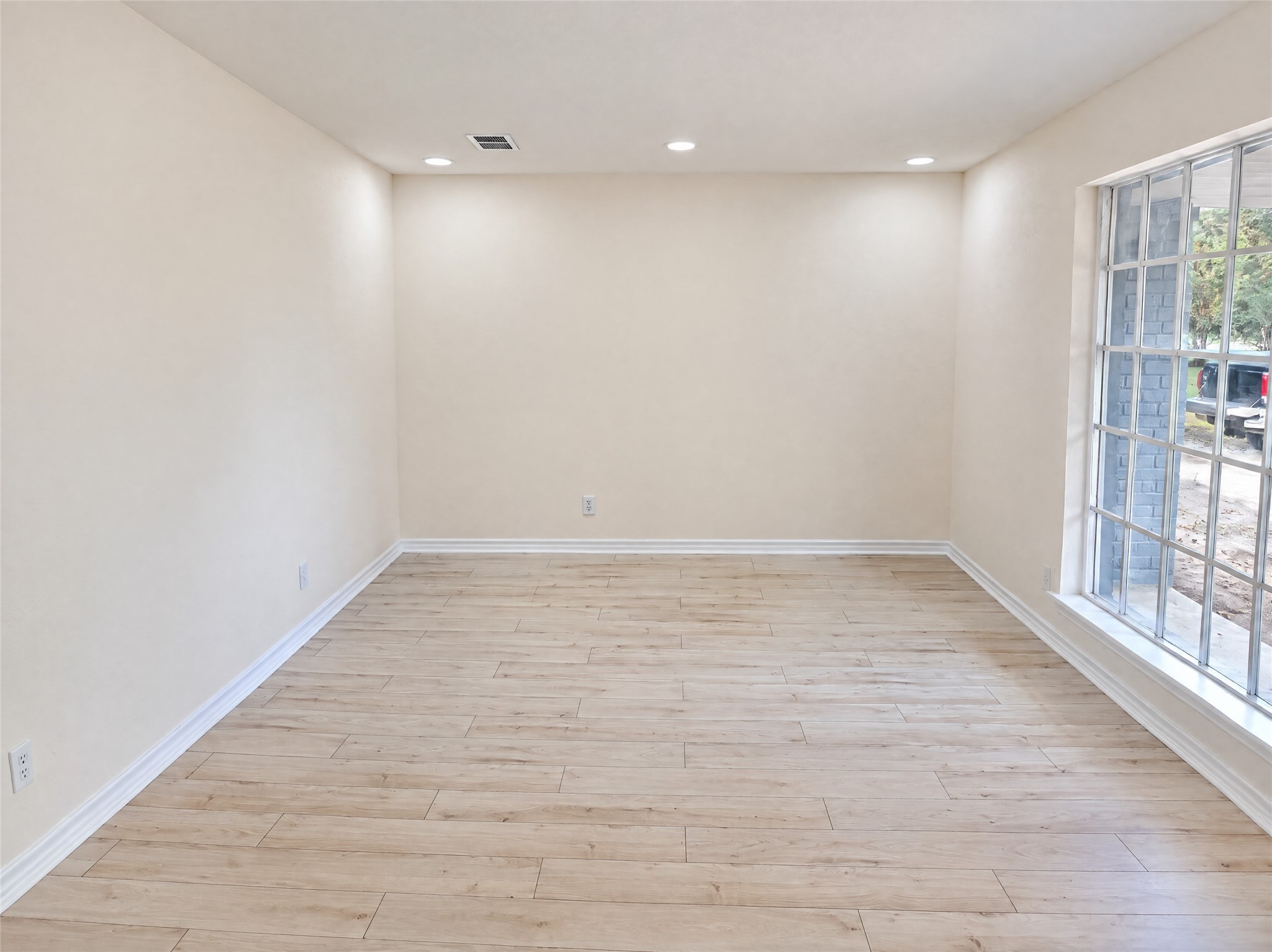 As you step inside, notice the seamless luxury wood-look flooring and soaring natural light pouring through large picture windows. This versatile open space offers an ideal setting for an elegant formal living area, bedroom or a comfortable reading lounge.