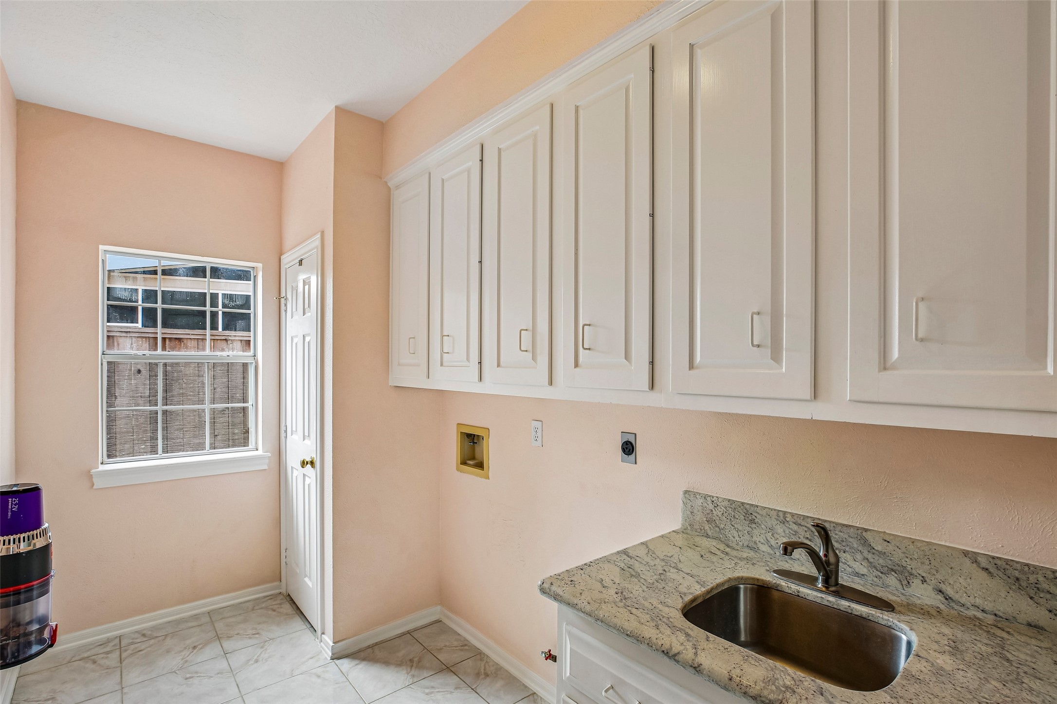 Laundry room is spacious with a utility closet and sink with granit countertop.