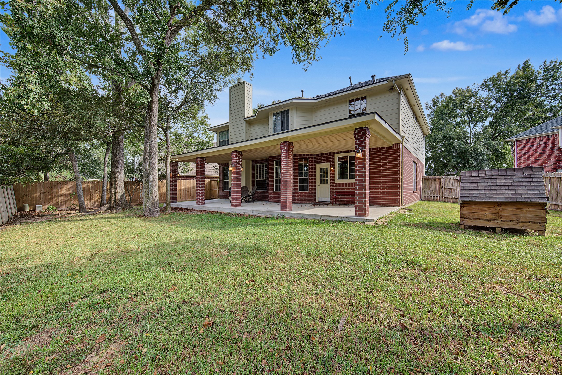 A sweeping view of the home, patio, and backyard