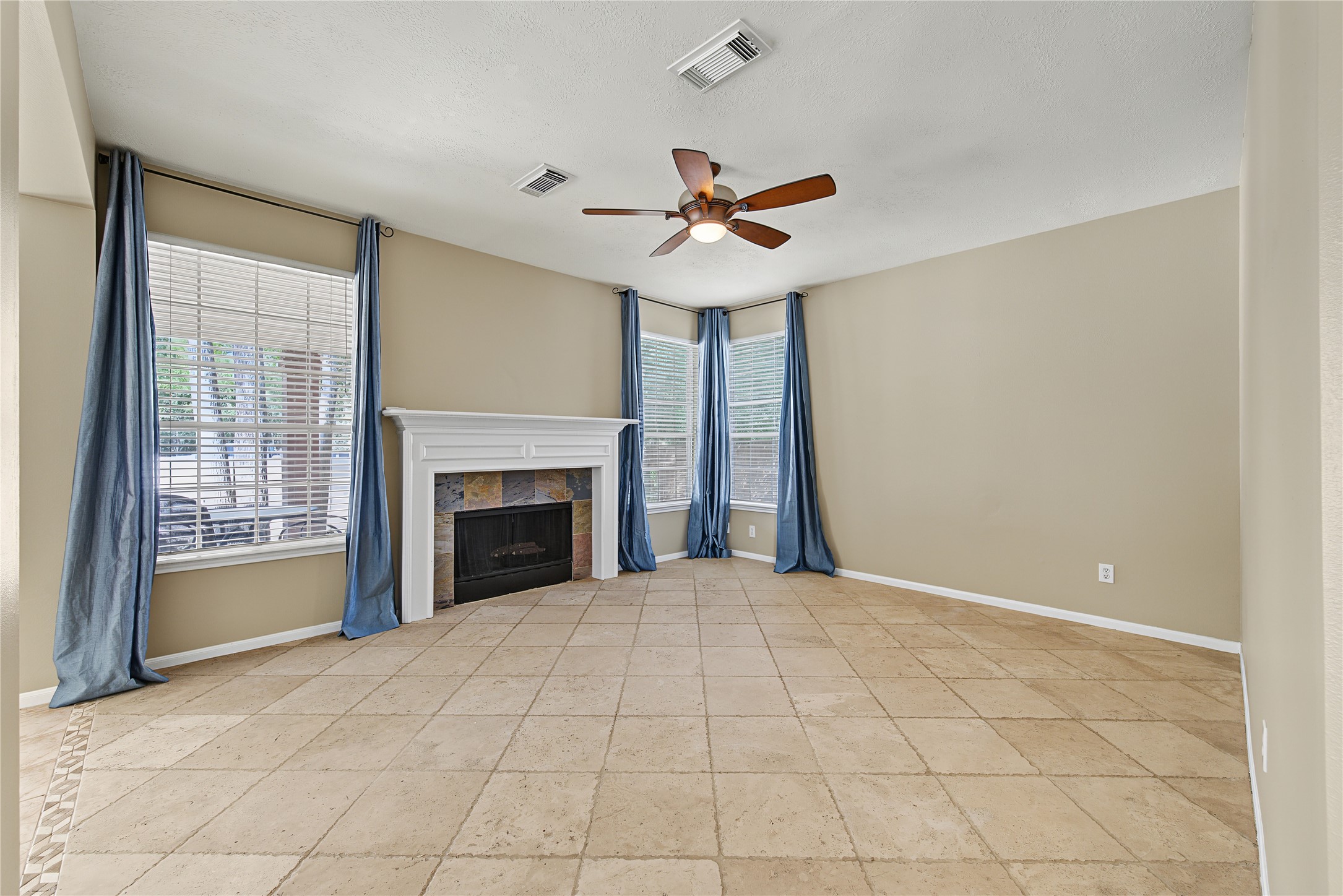 Spacious family room with a fireplace and windows overlooking the backyard