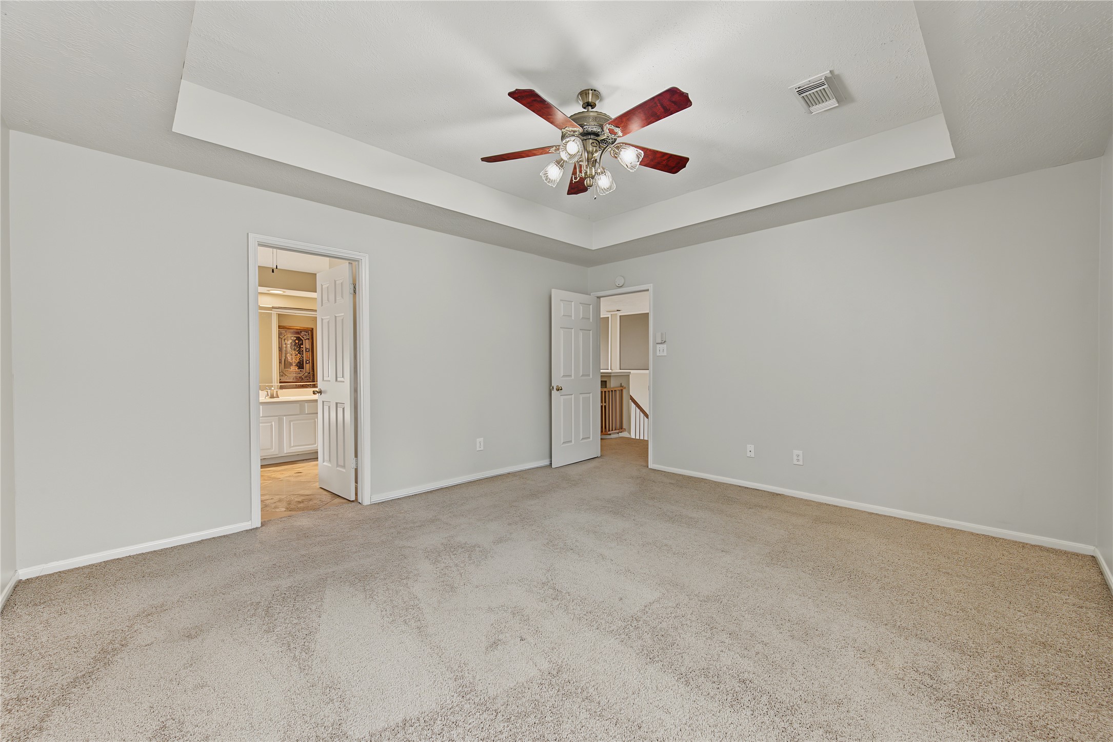 Another view of the primary suite, including the adjoining bath entrance