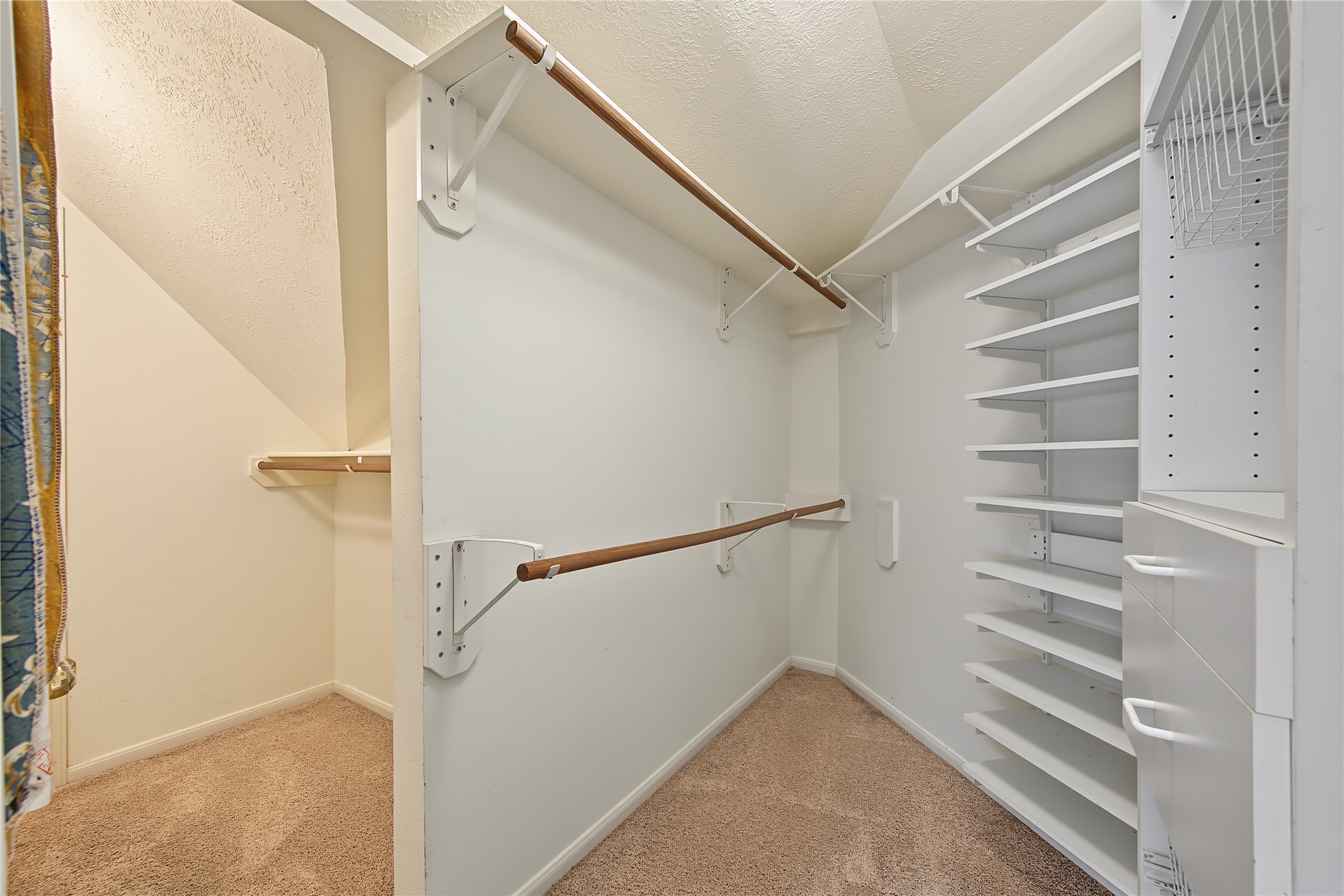 Generous closet space with built-in shelving and access to an additional storage area