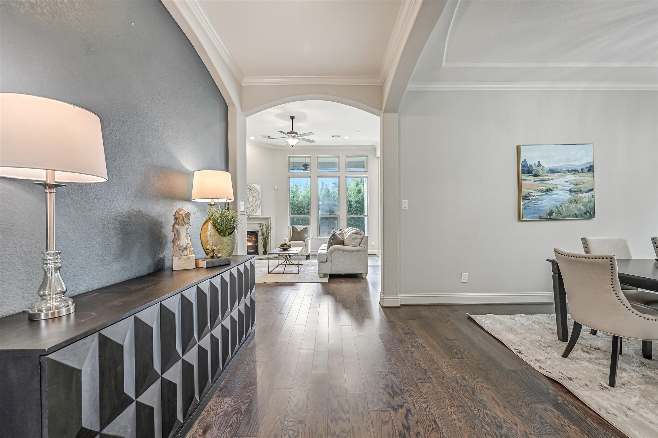 From the dining room, the wide arched opening draws you toward the family room beyond. Continuous luxury vinyl plank flooring connects the spaces, while the recessed accent wall adds architectural interest along the way.