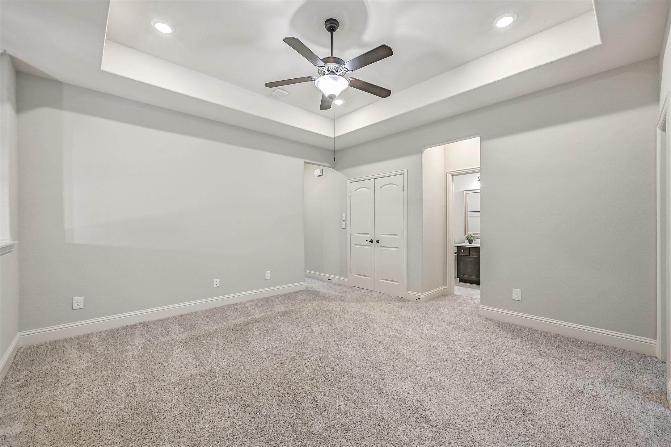 Another look at the game room shows off its attractive tray ceiling, generous floor space & double-door storage closet. With room for a media setup, game table or comfortable seating, this flexible space can easily suit a variety of needs.