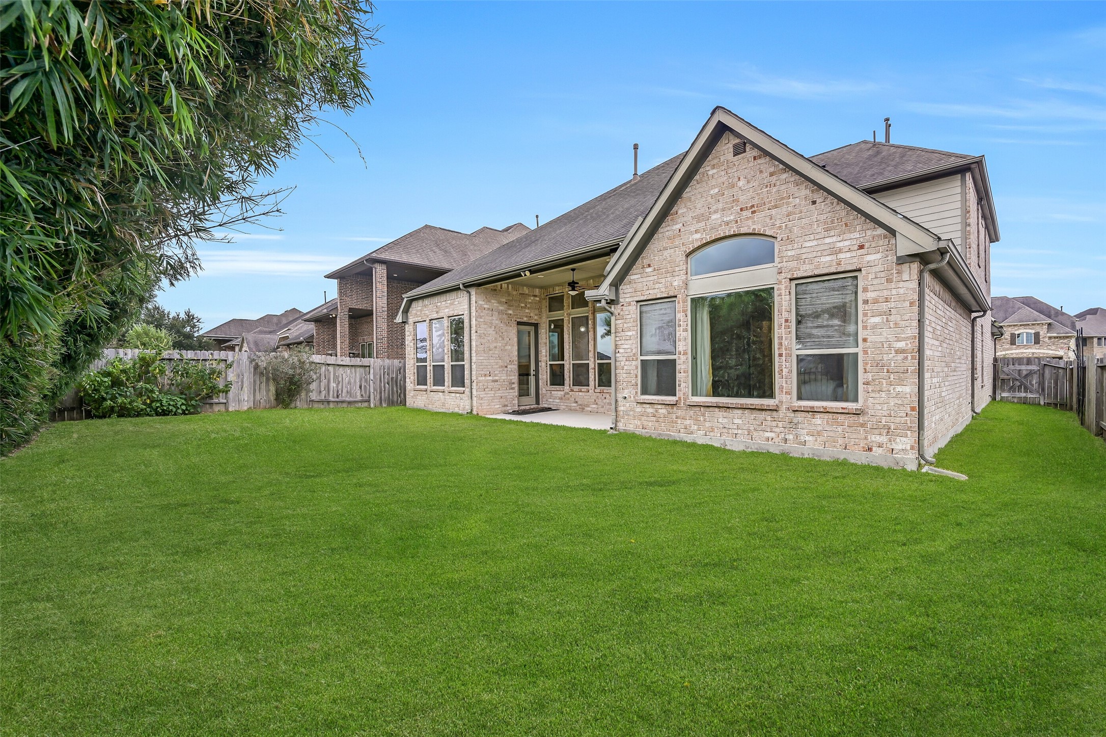 Out back, a spacious fenced lawn offers plenty of room for outdoor activities, with established bamboo providing privacy-enhancing screening along the rear fence. A covered patio with gas stub adds a convenient spot for grilling or relaxing outdoors.
