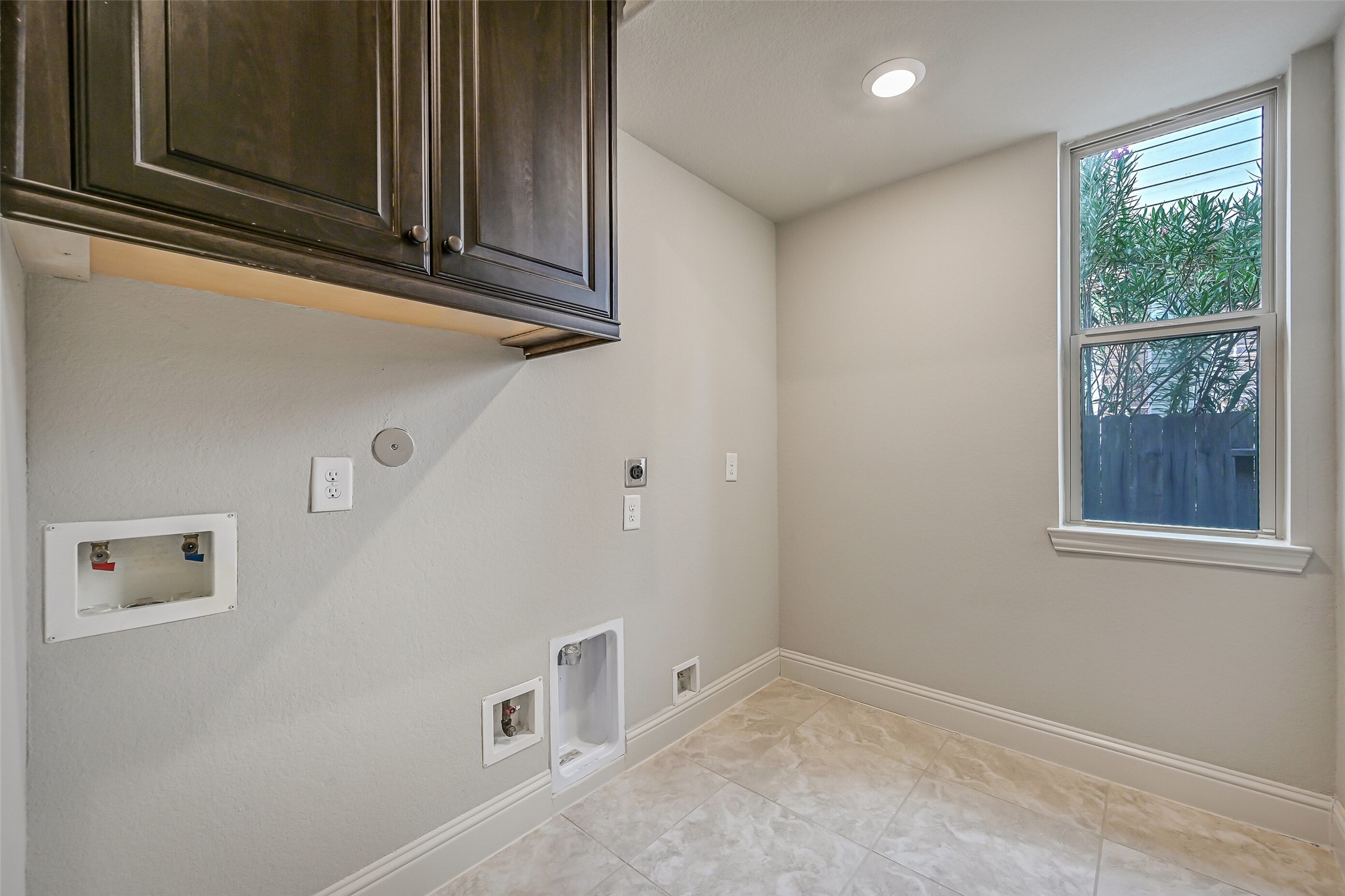 Tucked near the garage entrance, the spacious utility room offers both gas & electric dryer connections, overhead cabinetry, a utility closet & room for an additional refrigerator. A side-facing window brings in natural light, too!