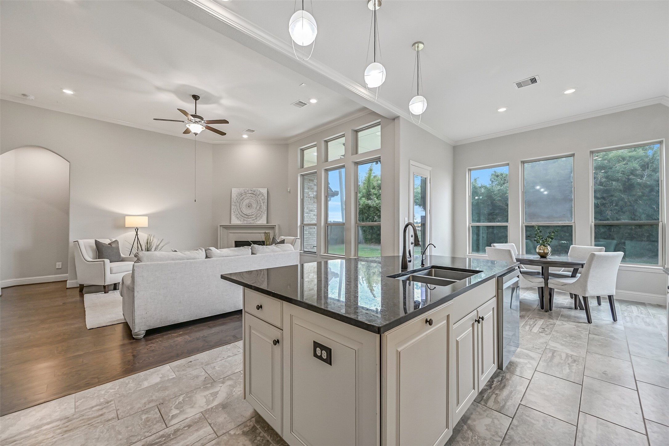 This view really captures the open flow between the kitchen, breakfast room & family room! A wall of windows brings in natural light, while the granite island provides a convenient connection between the living spaces.