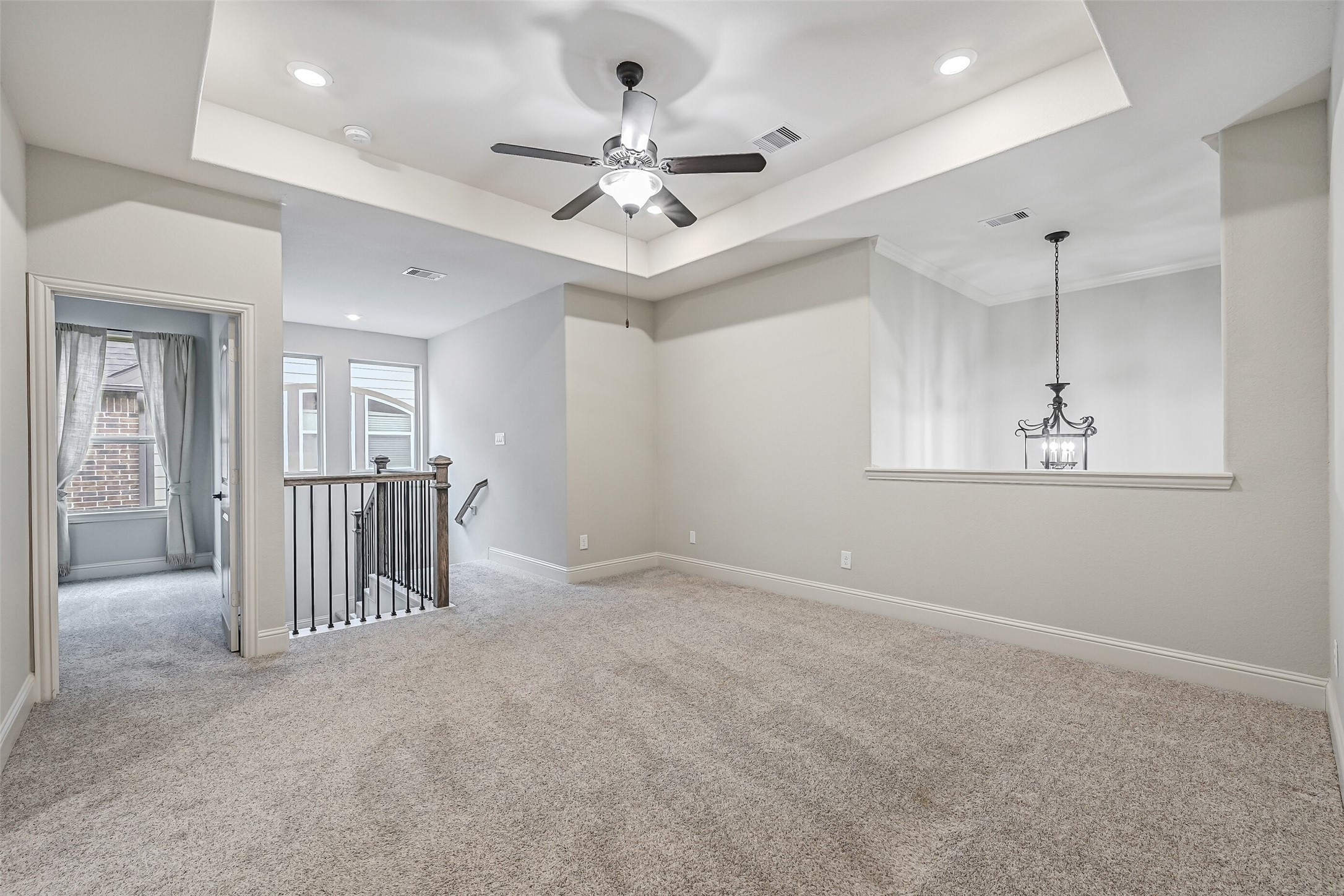 At the top of the staircase, a spacious game room offers a great second living area with plush carpeting, a tray ceiling, recessed lighting & a lighted ceiling fan. The open railing overlooks the staircase, while a nearby bedroom & full bath complete this portion of the second floor.
