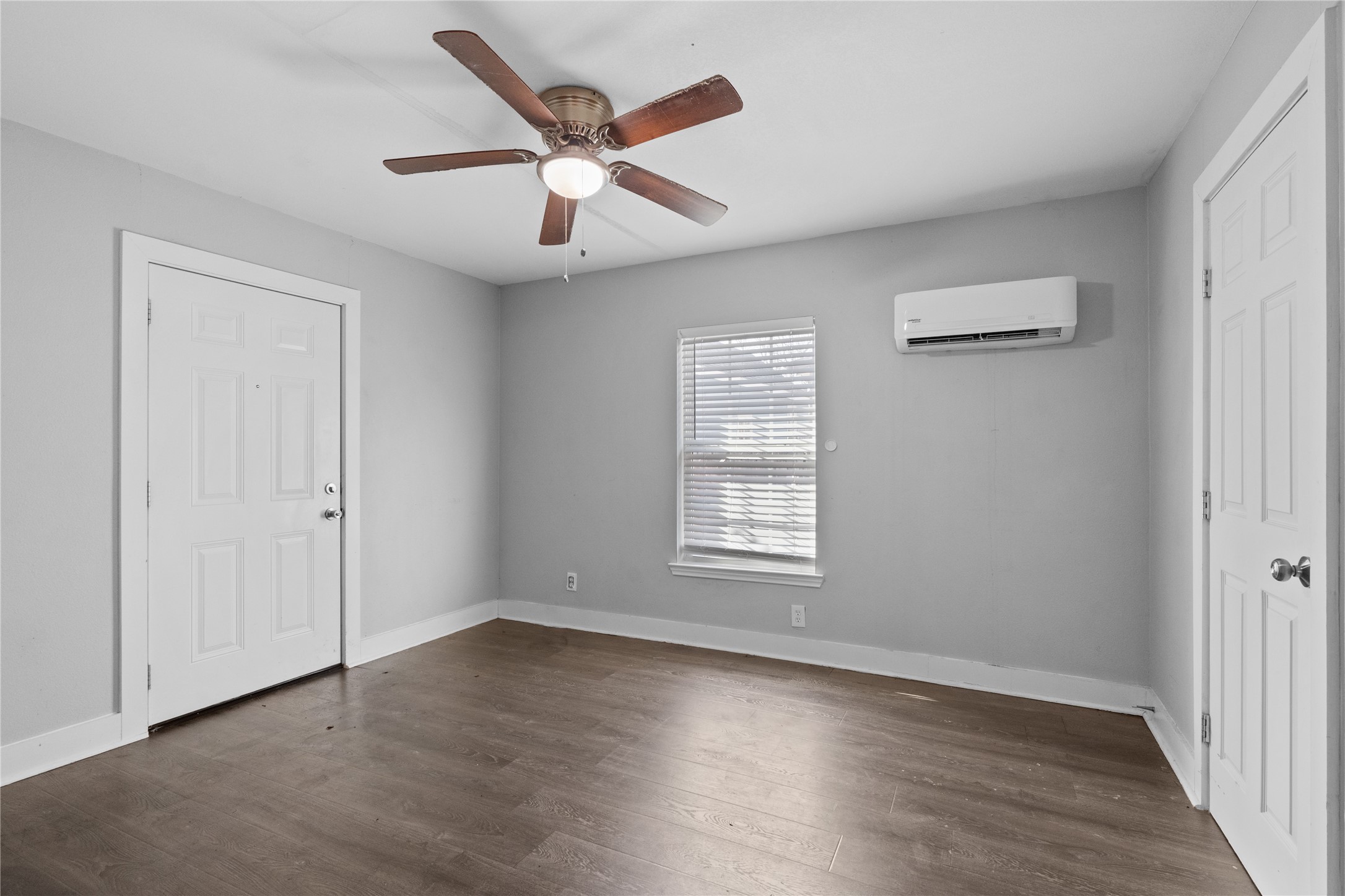 Spacious bedroom with continuation of laminate wood flooring