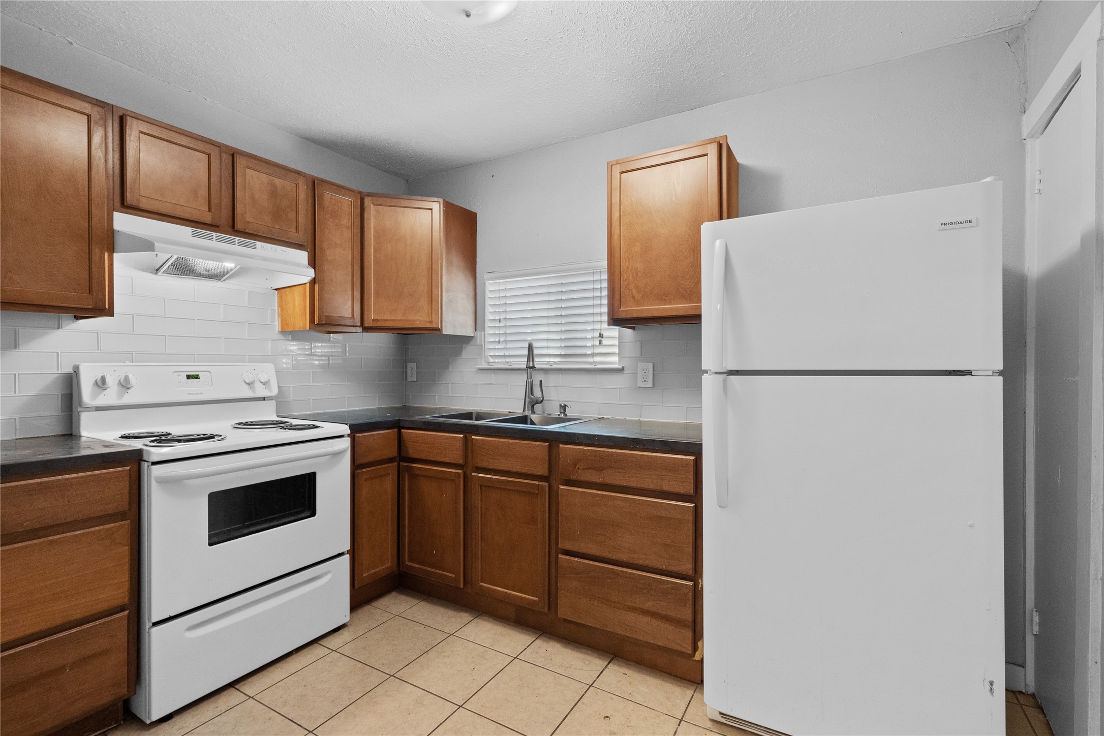 Spacious kitchen with electric stove and ceramic tile flooring