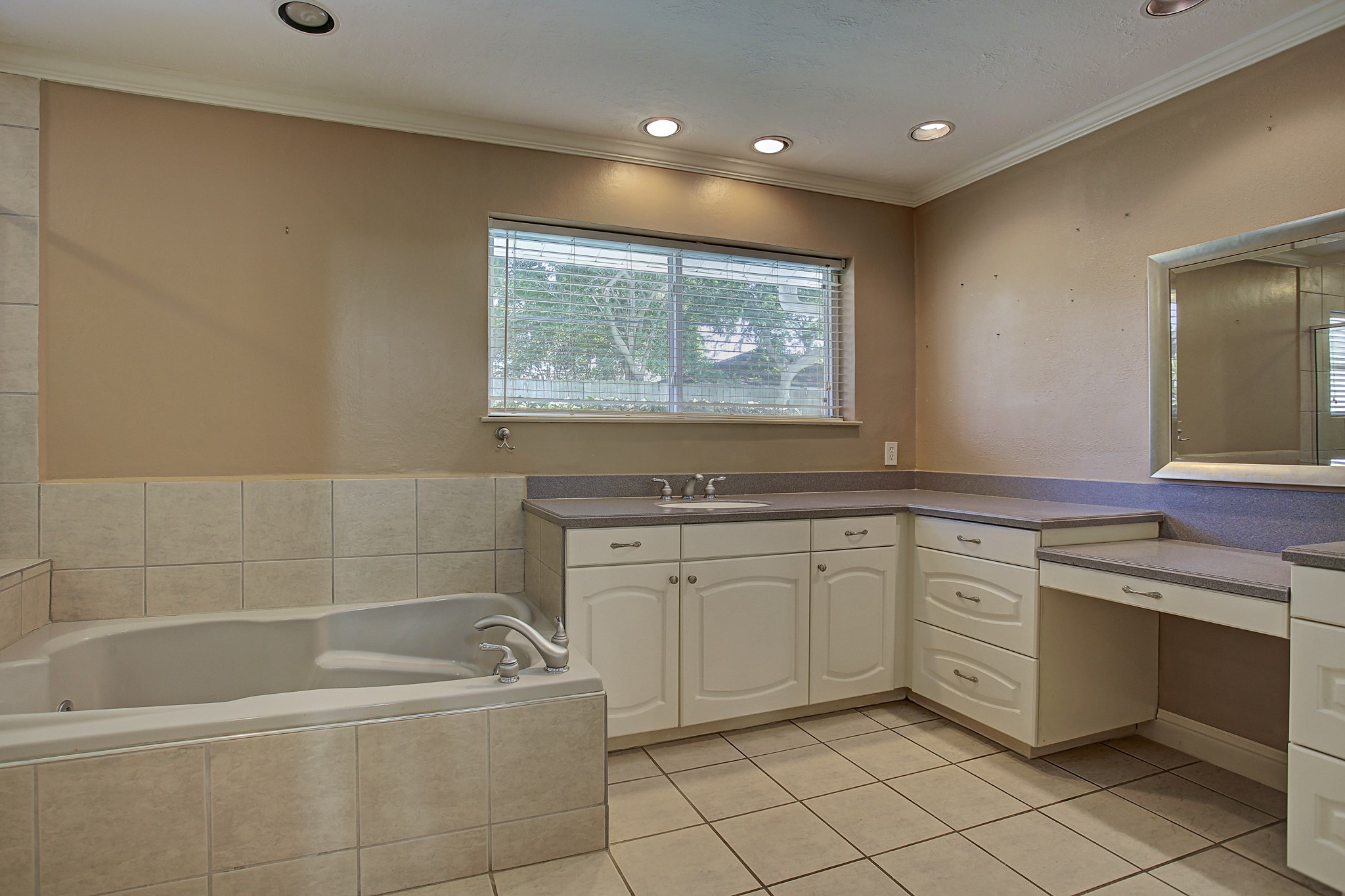 A long vanity, dedicated seated area, and soaking tub give the primary bath room for your whole routine.