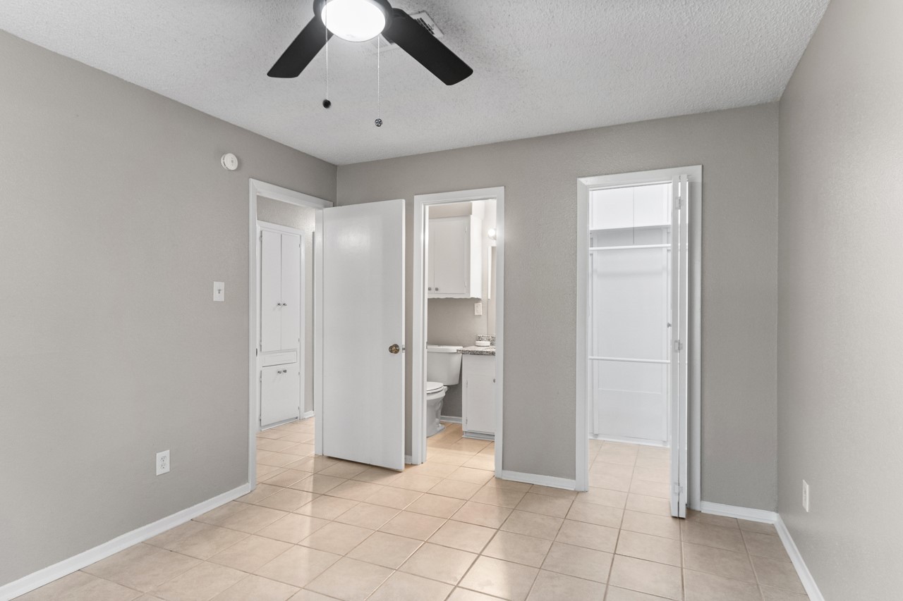Primary bedroom with a peak into the bathroom and walk-in closet.