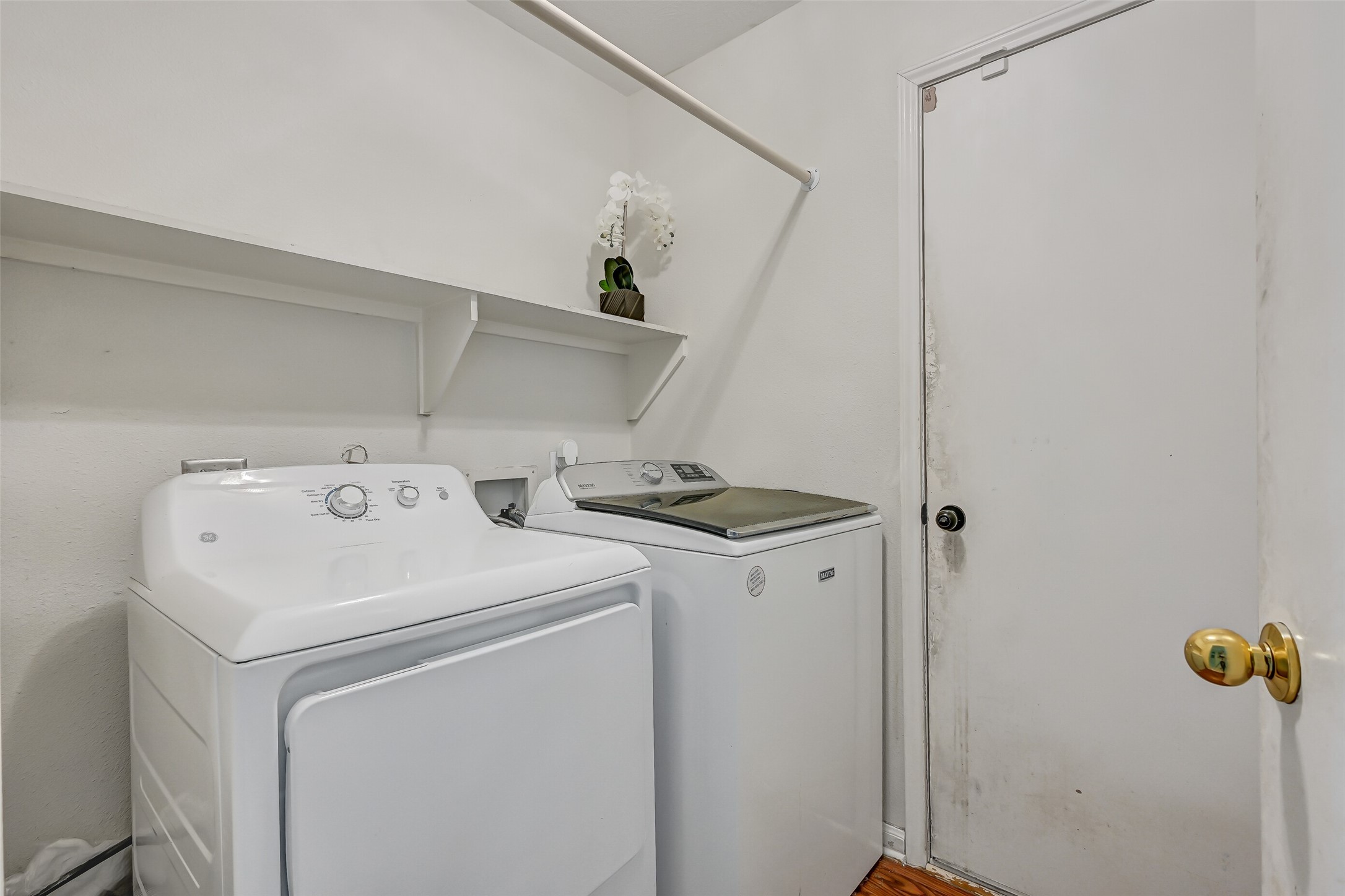 A dedicated indoor utility room provides space for a full-size washer and dryer along with convenient built-in shelving for laundry and household supplies.