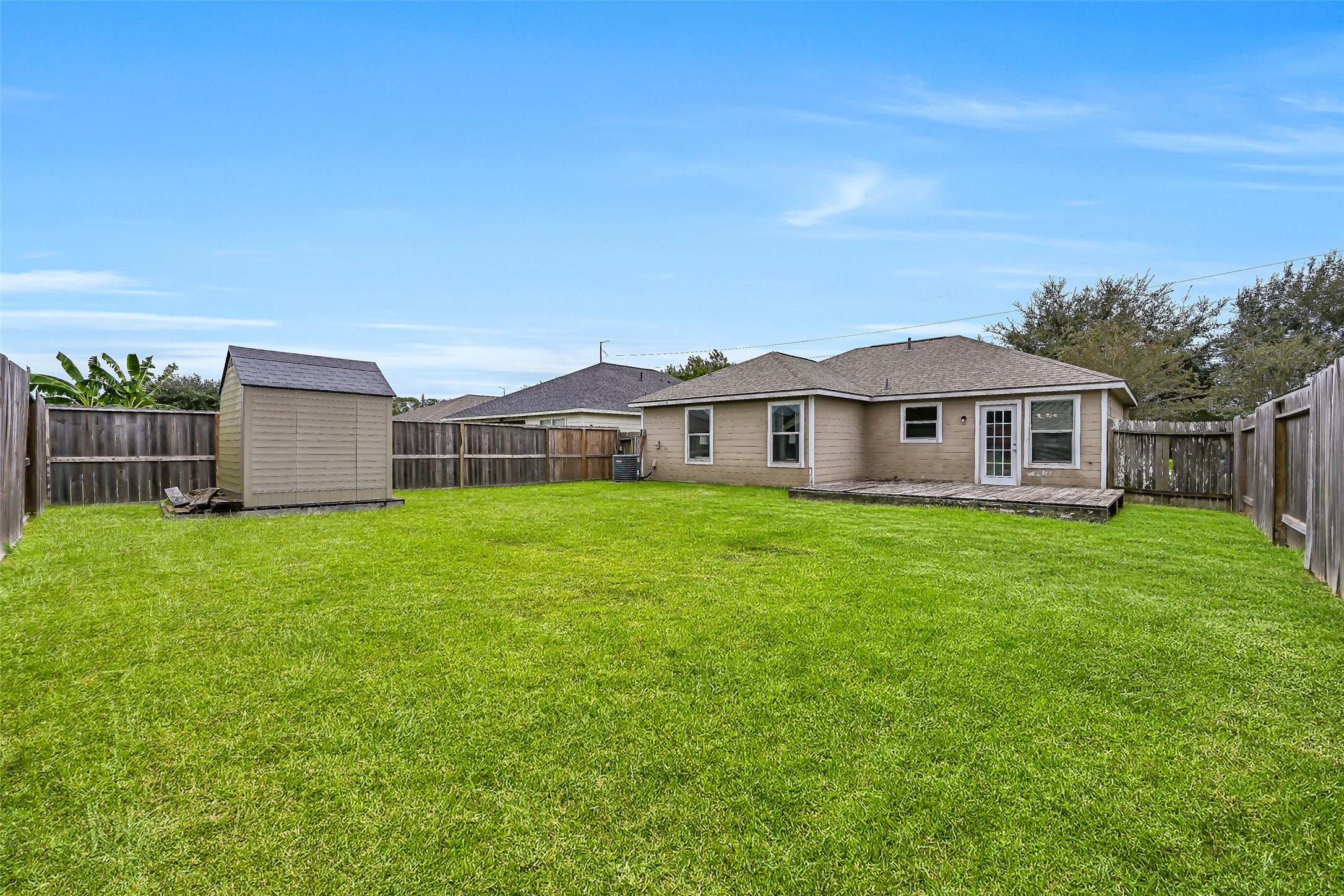 There's plenty of room to spread out in this spacious fenced backyard, with a broad expanse of lawn offering possibilities for pets, play, gardening, or future outdoor improvements.