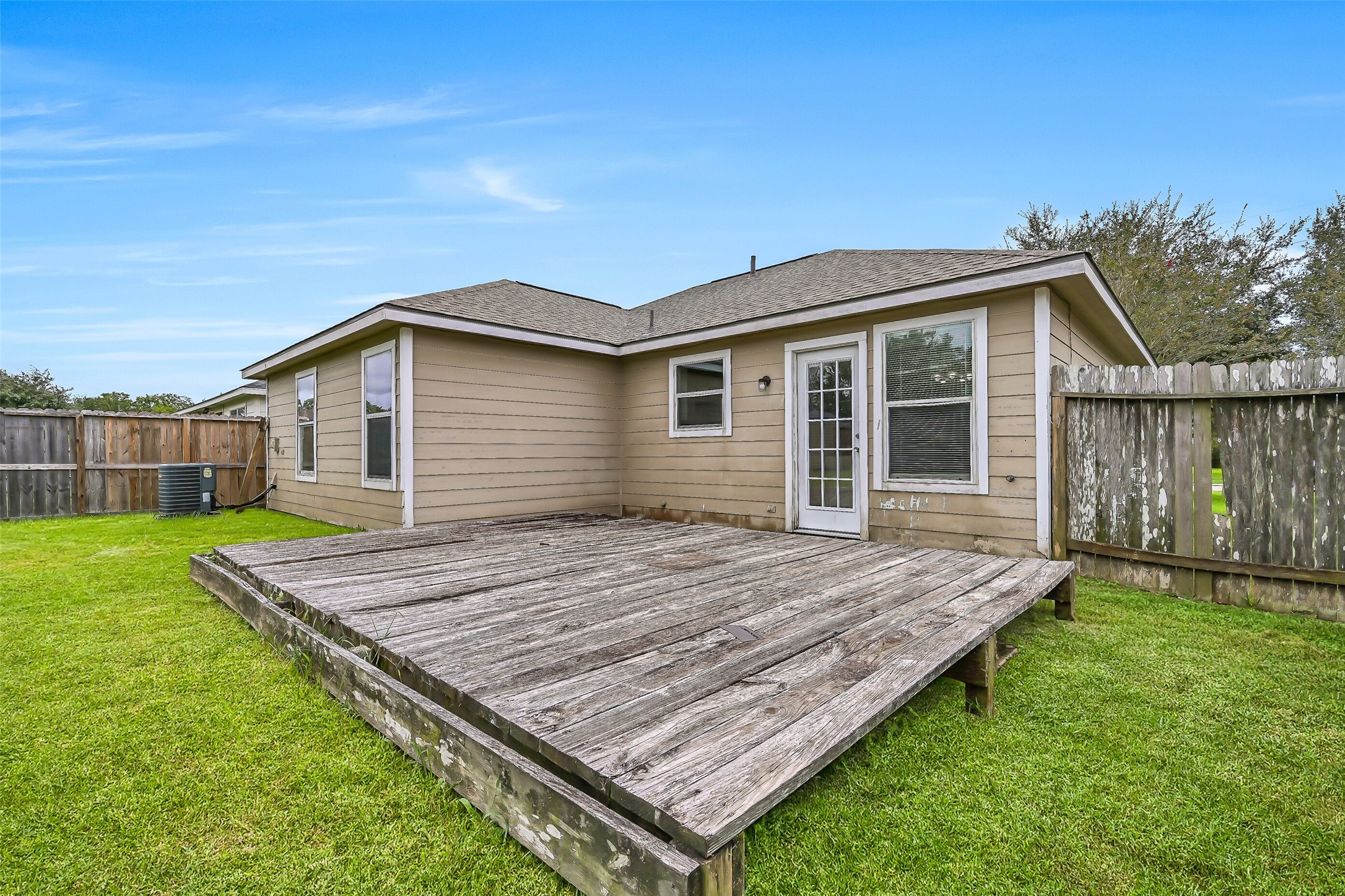 A large wood deck extends from the rear of the home, creating additional outdoor space just steps from the kitchen and dining area.