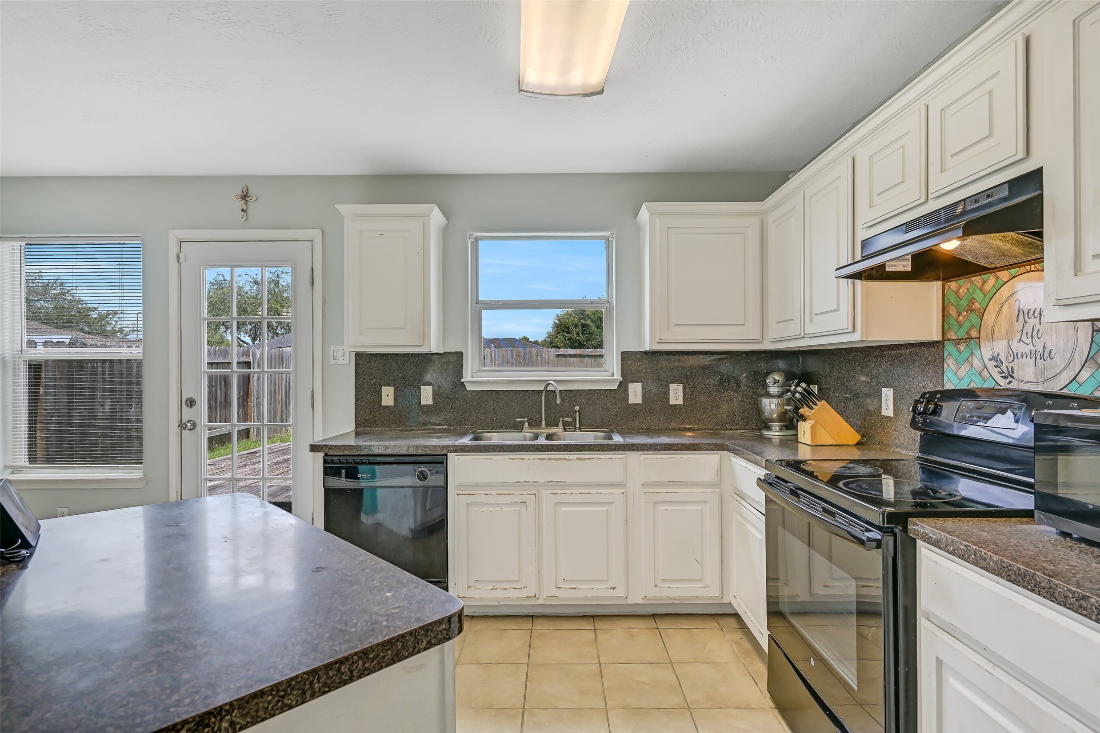 The kitchen's open design keeps the cook connected to the surrounding living and dining spaces, with a generously sized breakfast bar providing additional serving or casual dining space.