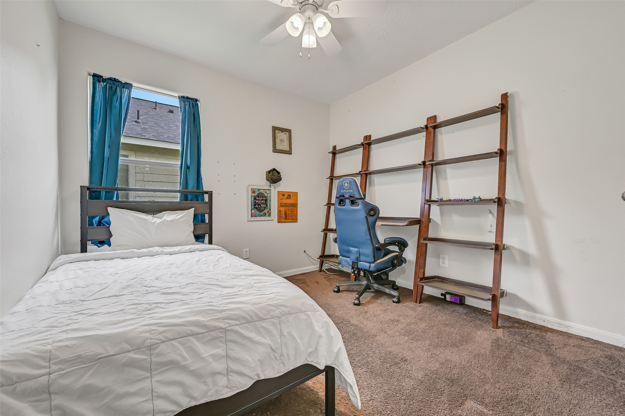 The third bedroom provides comfortable space for bedroom furnishings along with a ceiling fan and window for natural light.