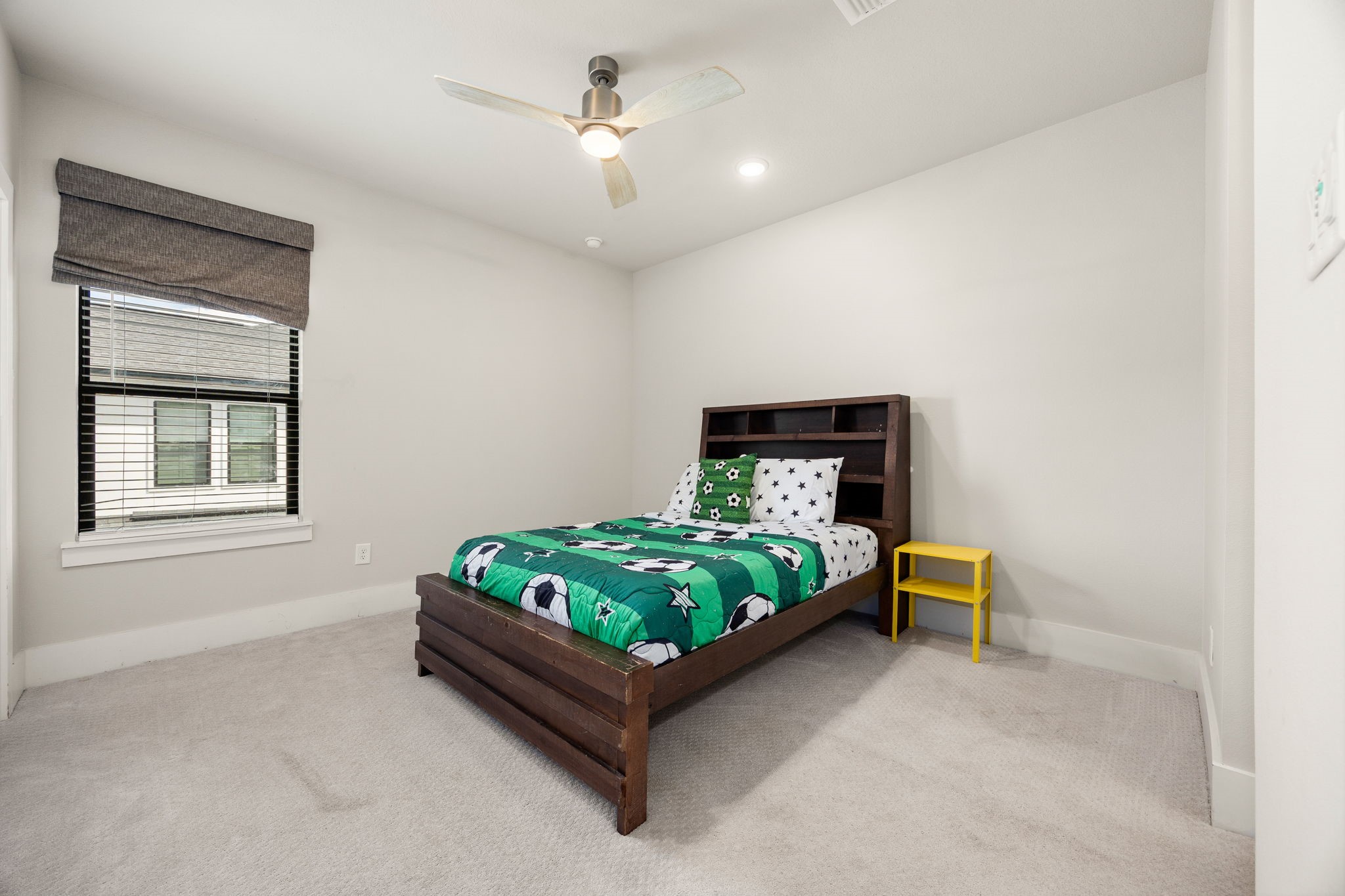 Comfortable secondary bedroom featuring a ceiling fan and neutral finishes.