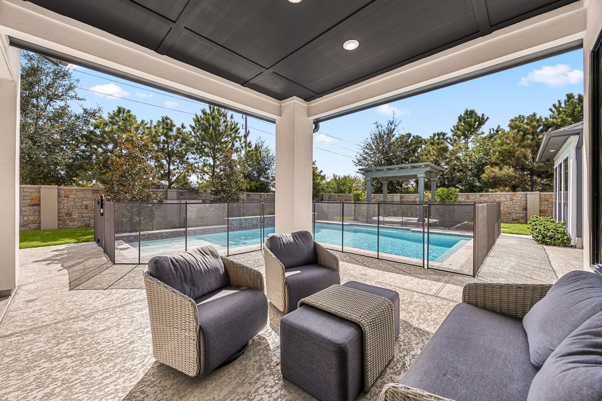 Enjoy outdoor living year-round on this inviting covered patio with comfortable seating and gorgeous backyard views.