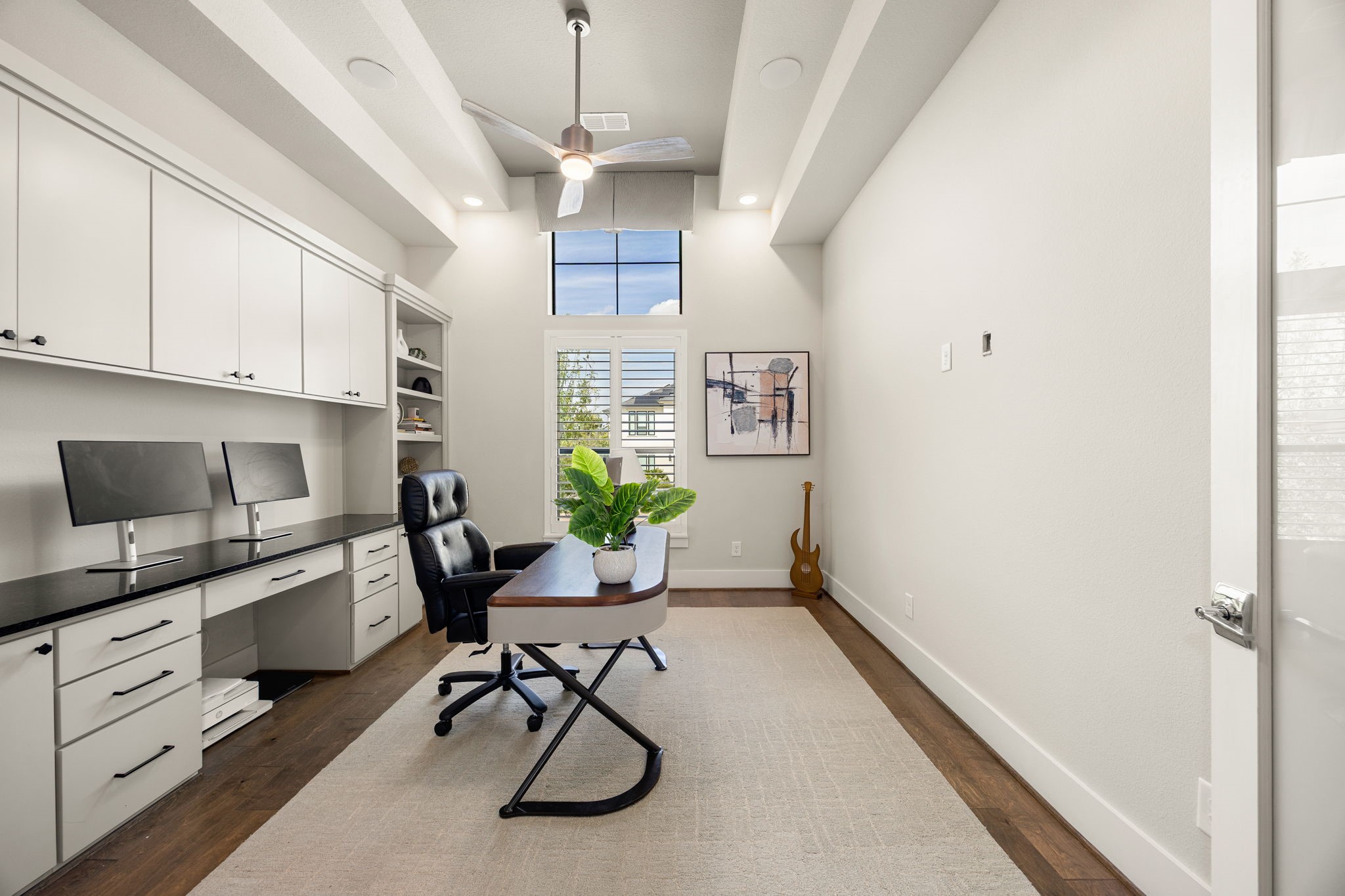 Elevated private home office featuring built-in cabinetry, recessed ceiling, beautiful flooring, and an ideal space for working from home.