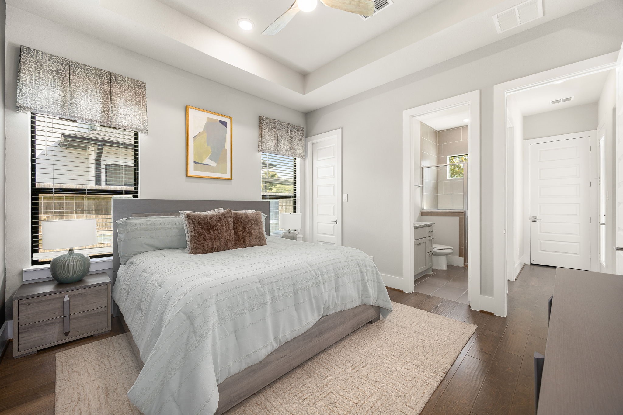Bright secondary downstairs bedroom featuring beautiful ceiling details, neutral colors, and generous natural light.