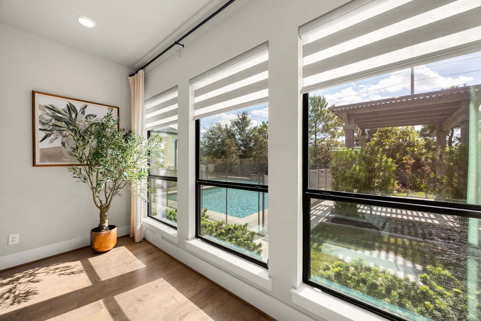 Enjoy peaceful views of the backyard and sparkling pool through the expansive primary suite windows.