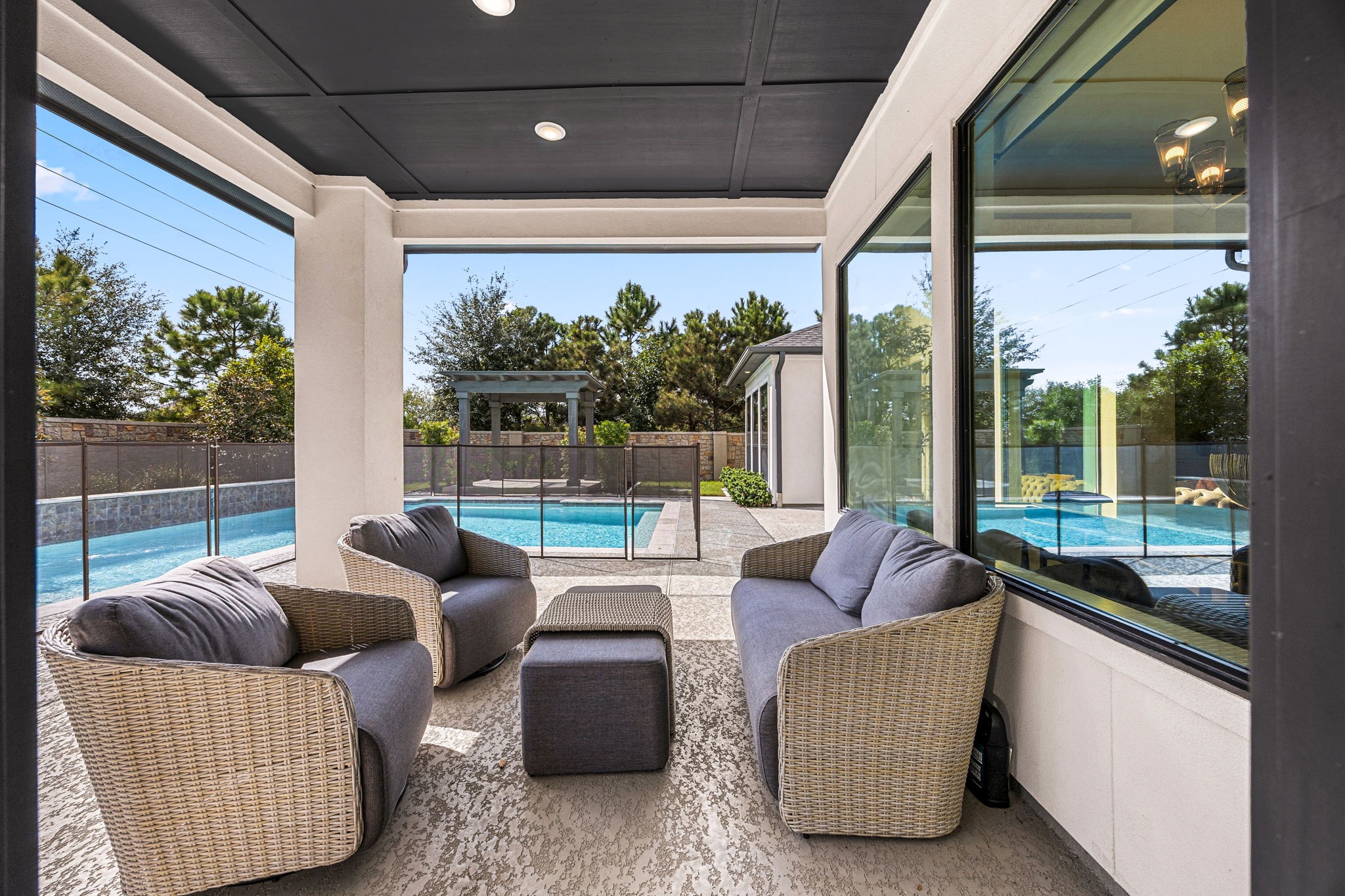 Relax on the spacious covered patio overlooking the sparkling swimming pool and beautifully landscaped backyard.