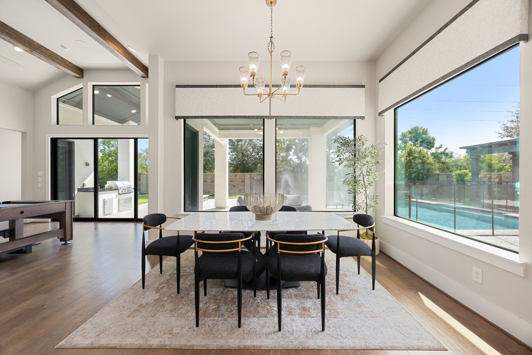 Elegant breakfast area surrounded by large windows, offering beautiful backyard views and abundant natural light.