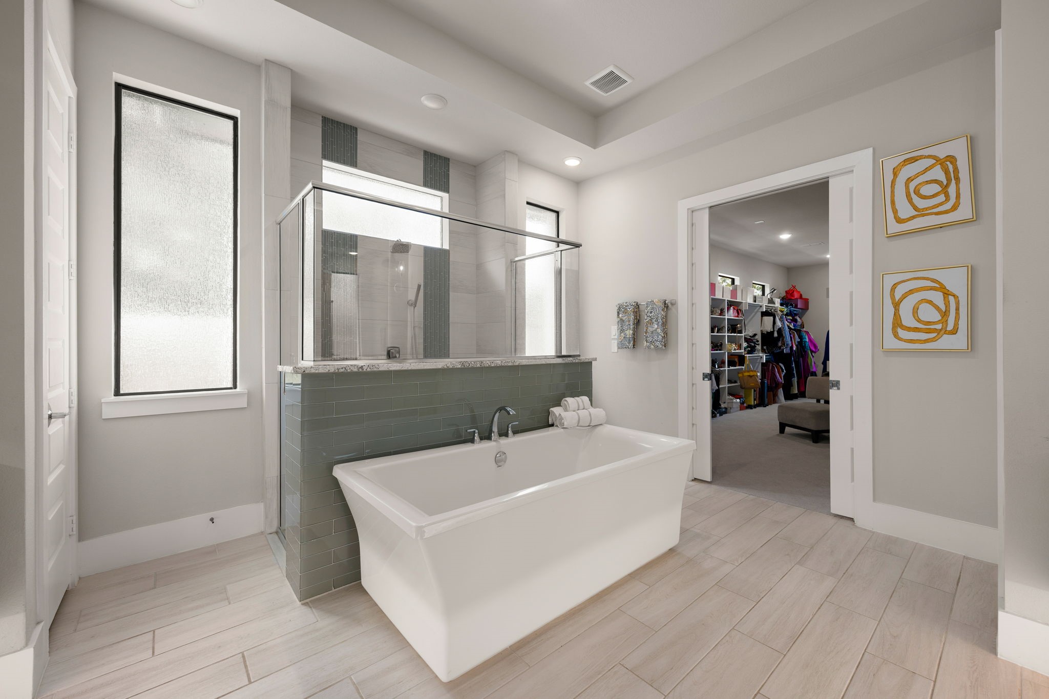 Unwind in the beautiful freestanding soaking tub surrounded by natural light and elegant bathroom finishes.
