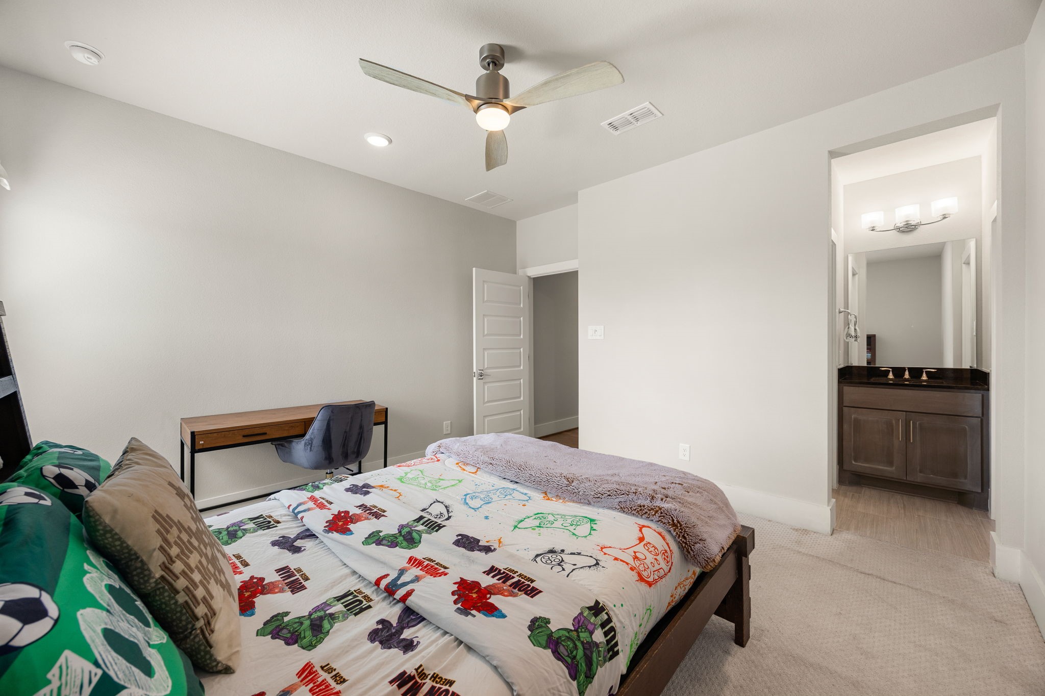 Spacious secondary bedroom with neutral finishes, ceiling fan, an ensuite bathroom, and plenty of room for comfortable living.
