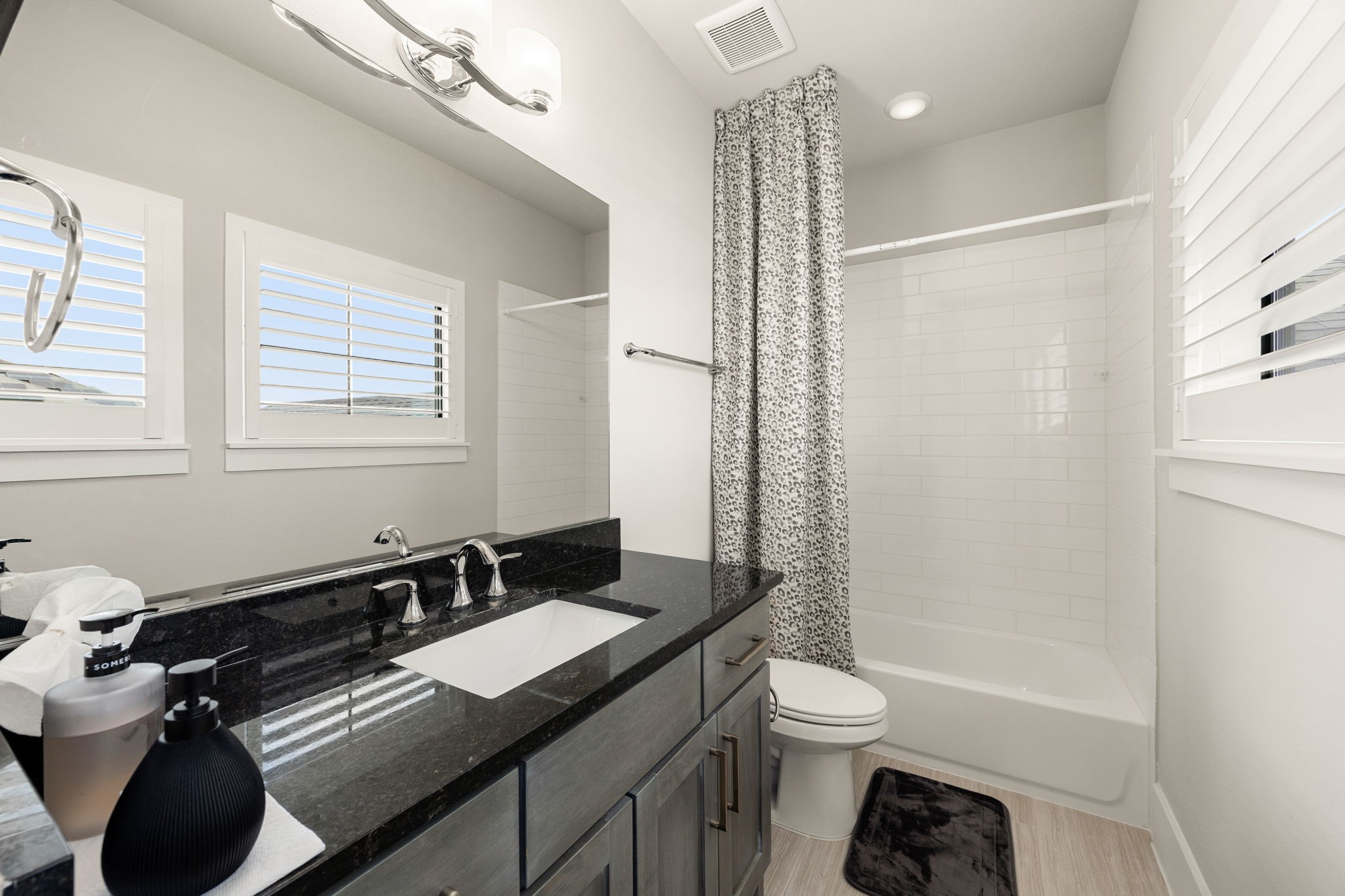 Beautiful secondary bathroom featuring a spacious vanity, updated-style finishes, and plenty of natural light.