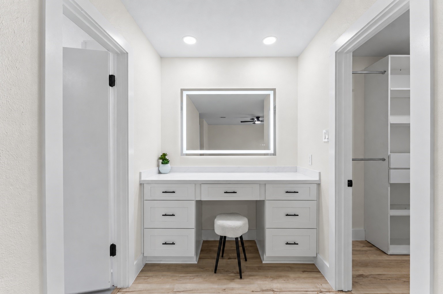 The primary bedroom has a luxury vanity between the walk in closet and the bathroom