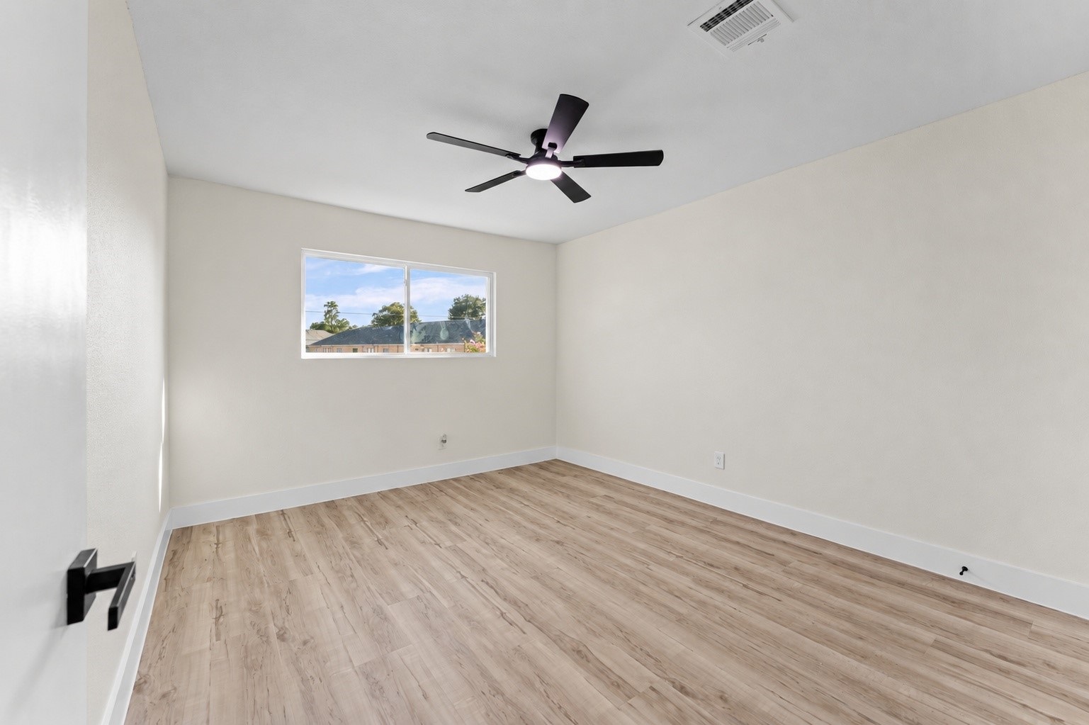 One of the secondary bedrooms, with updated flooring, windows, and a new fan.