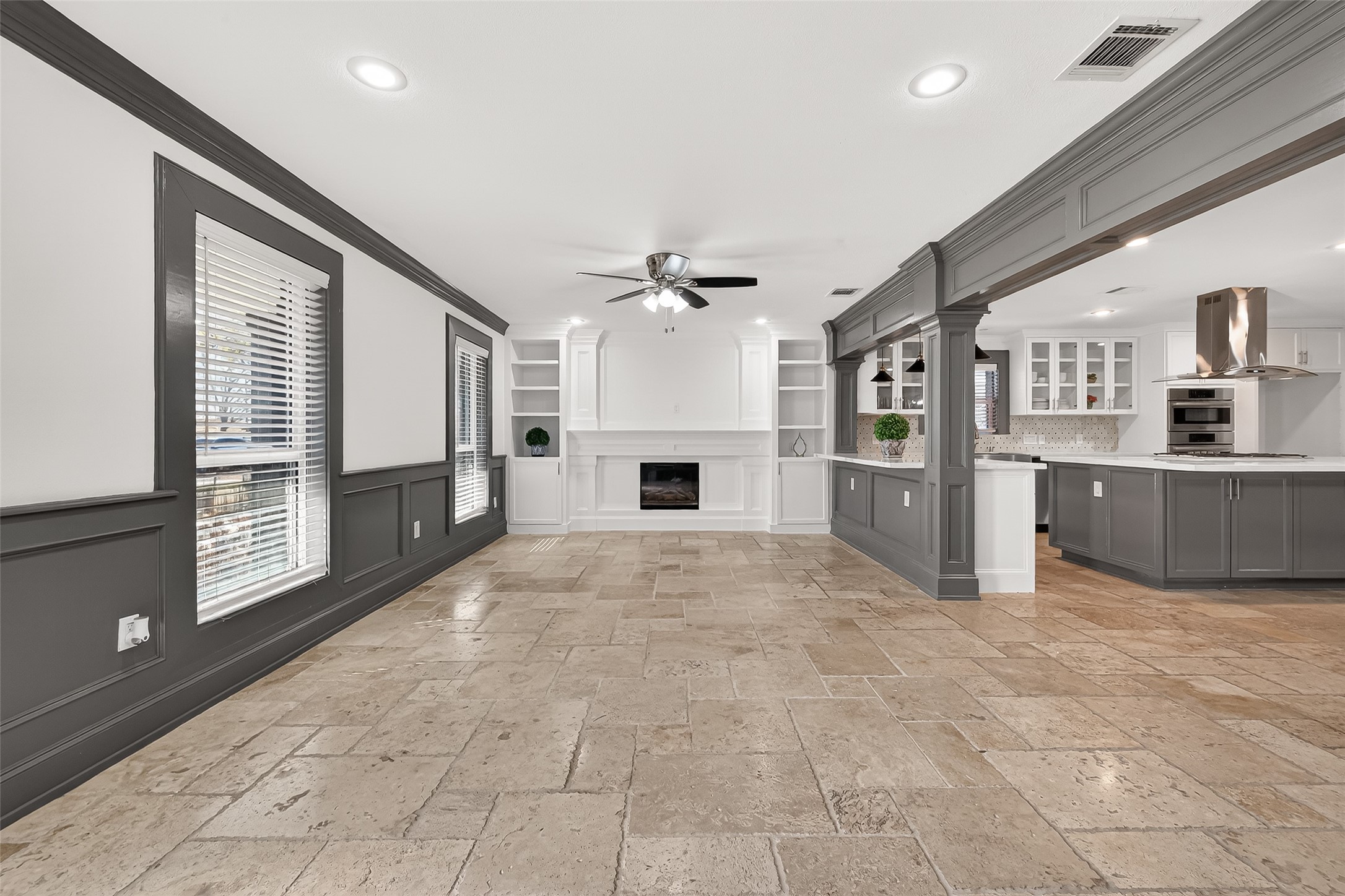 Features include a ceiling fan, built-in shelving, and a charming fireplace, creating a cozy yet elegant atmosphere.