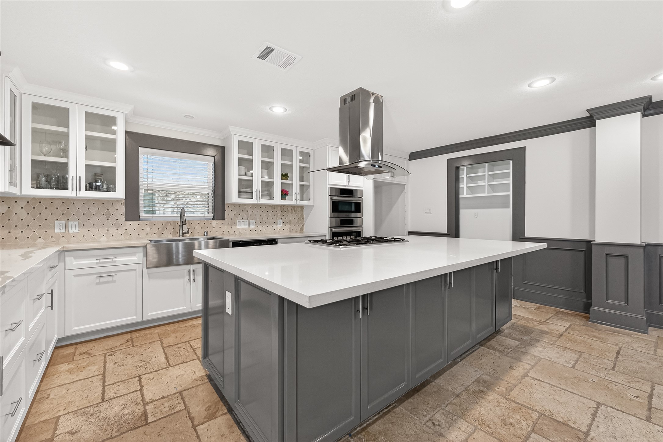 It includes stainless steel appliances, ample storage, and a stylish range hood.