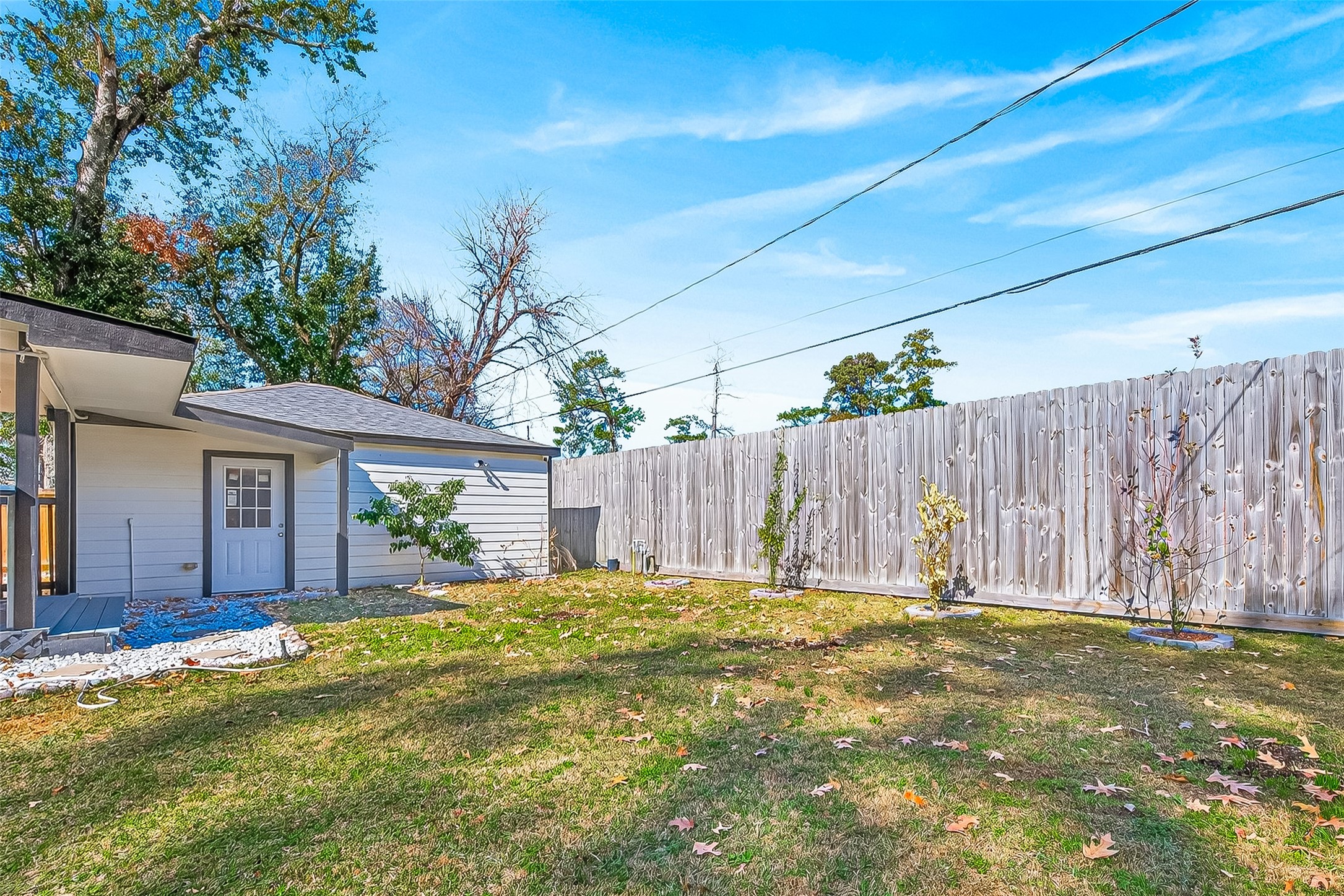 A backyard with a grassy lawn and a wooden fence.